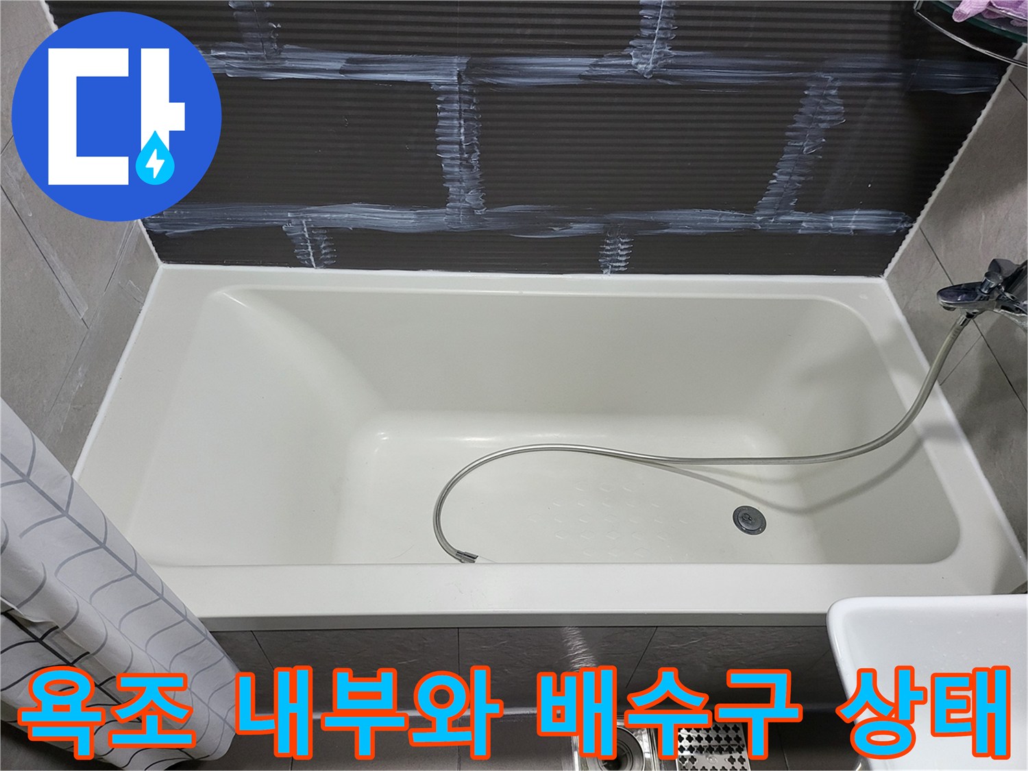 깨끗하게 정돈된 욕조 내부의 배수구와 샤워기 호스 모습