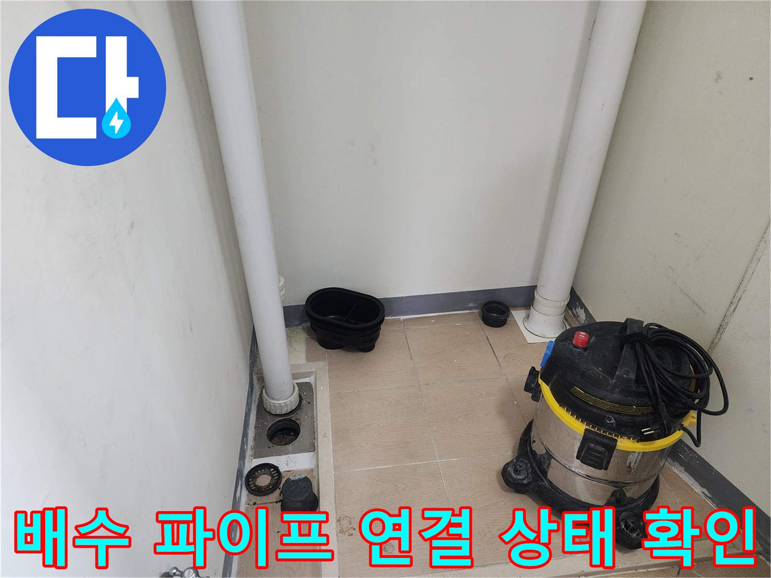 세탁실 배수 파이프-연결 부위의 누수 여부를 점검하는 장면