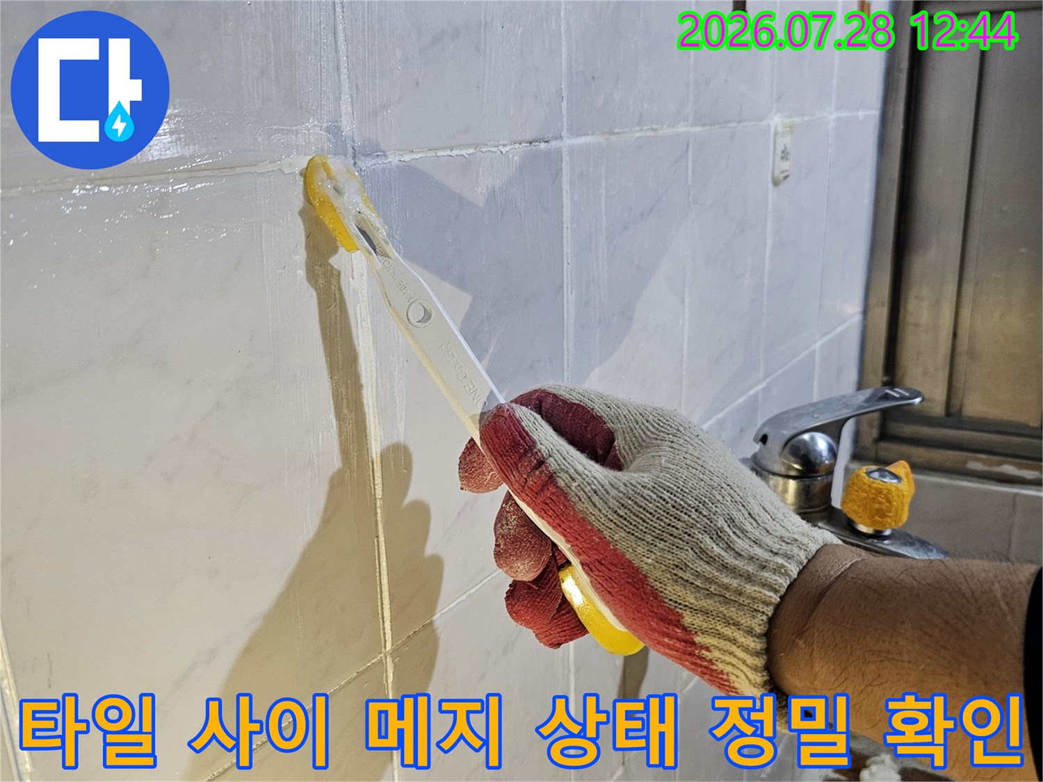 작업자가 장비를 사용하여 타일과 타일이 만나는 지점을 점검하는 장면