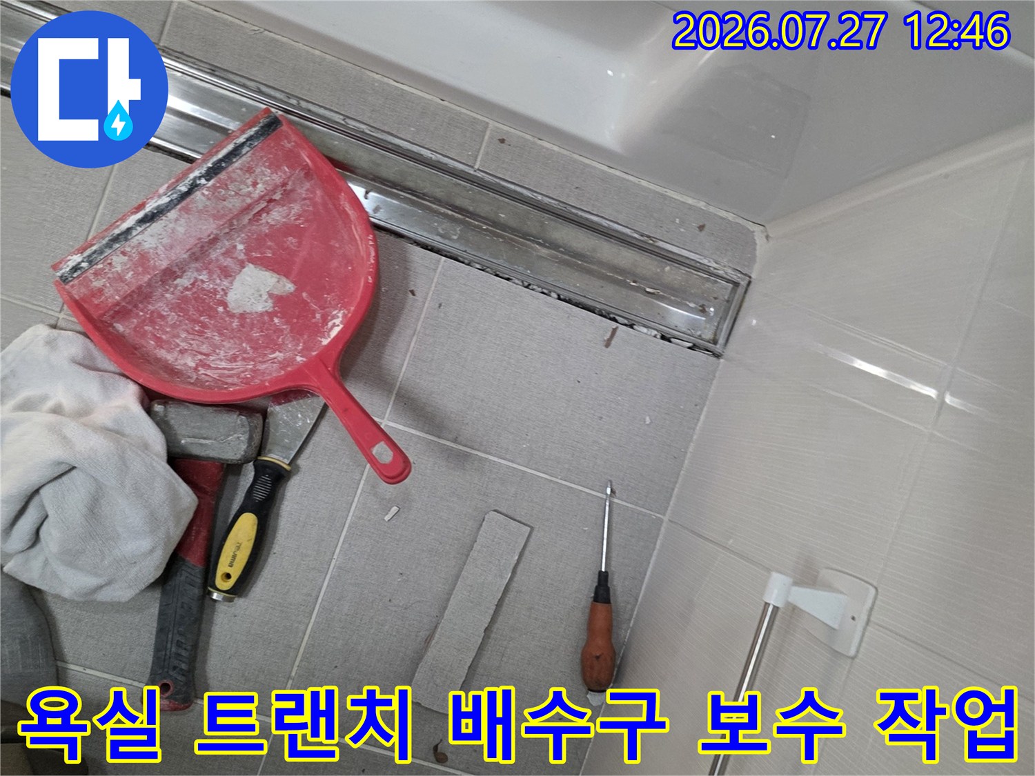 금속제-트랜치-배수구가-설치된-욕실-바닥과-작업용-헤라