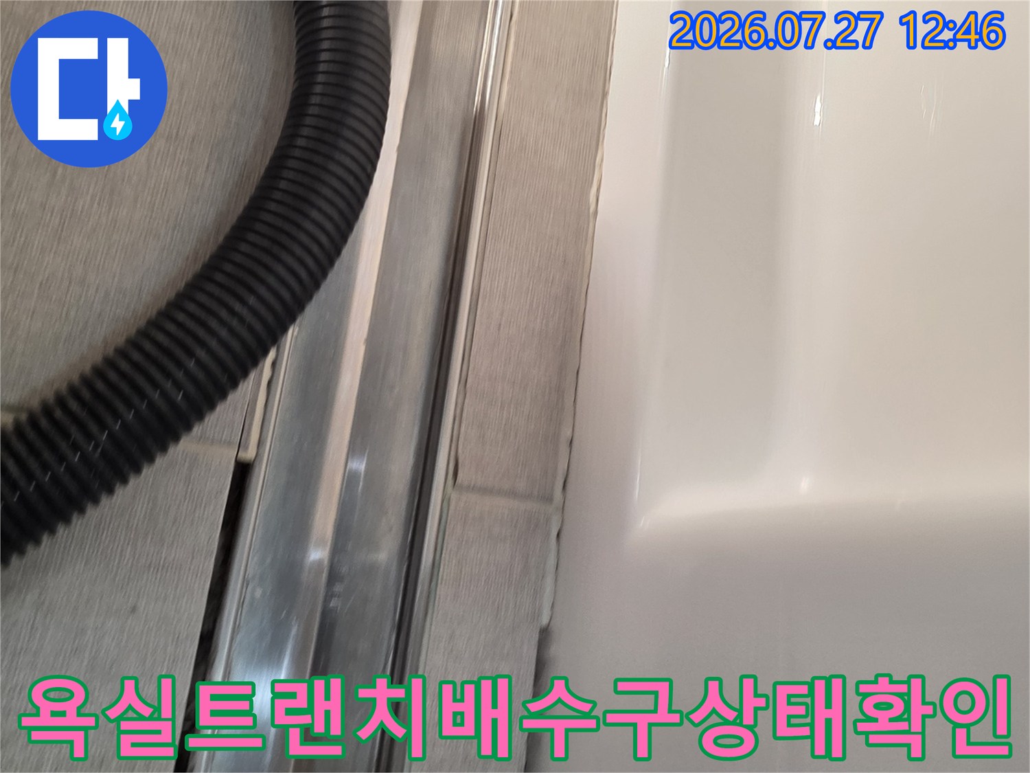 욕실 바닥에 설치된 금속 재질의 트랜치 배수구와 주변 타일 틈새 모습