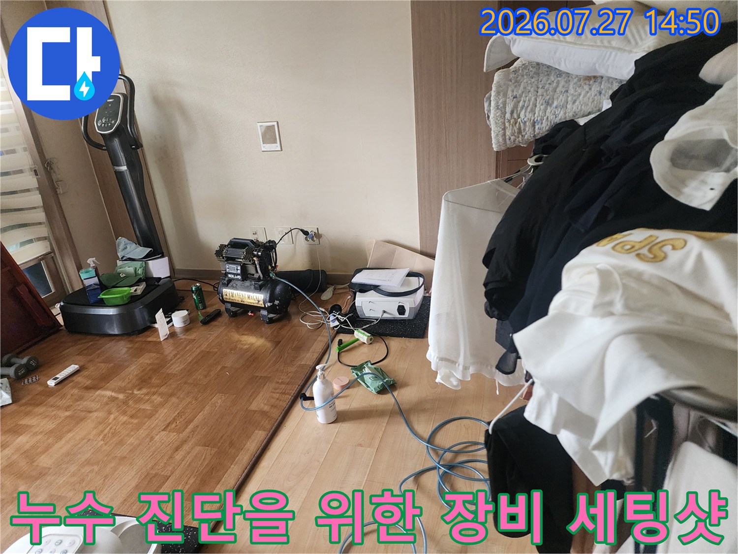 바닥에 놓인 공압 테스트기-누수 위치 추적을 위해 연결된 파란색 호스와 측정 장치들