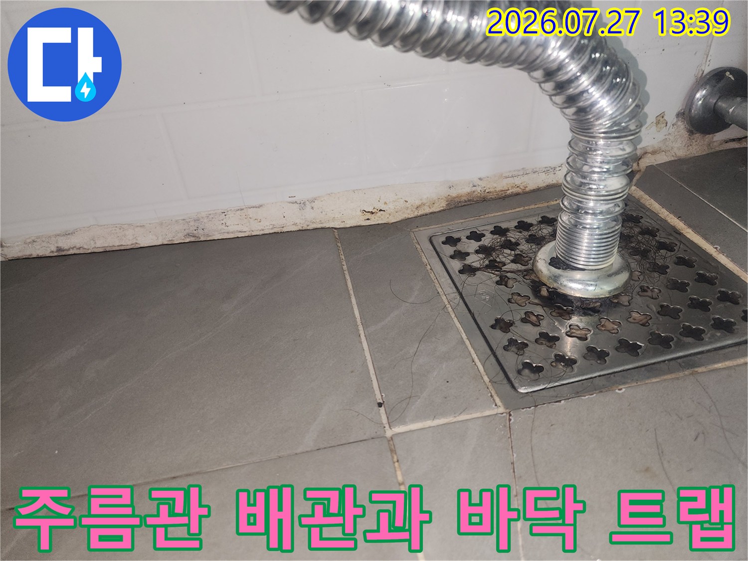 금속 재질의 하수구 거름망 유가와 연결된 은색 주름관의 설치 모습