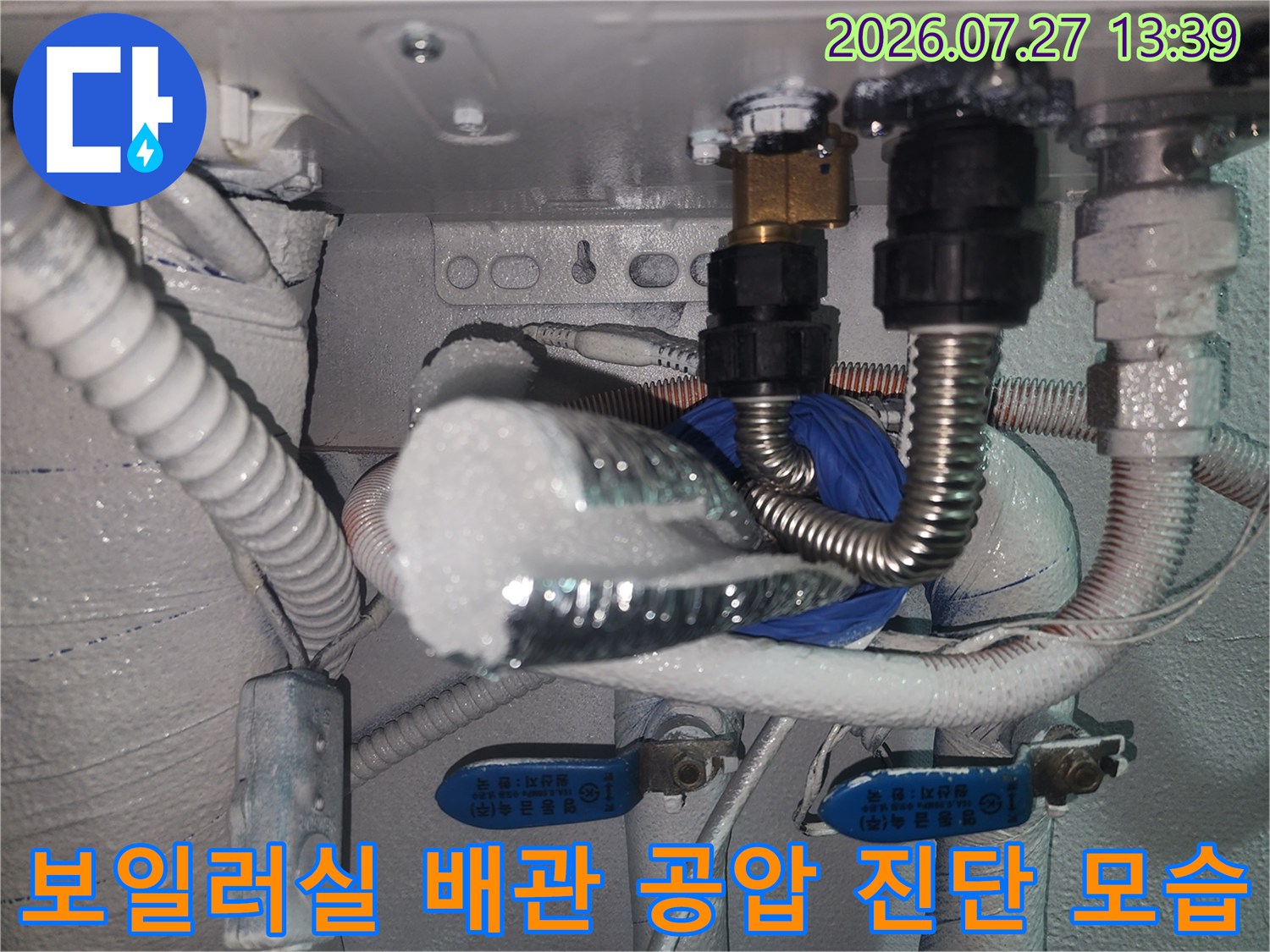 보일러 하단 배관에 정밀 진단을 위해 연결된 측정 장비와 보온재-마감된 상태의 배관 사진