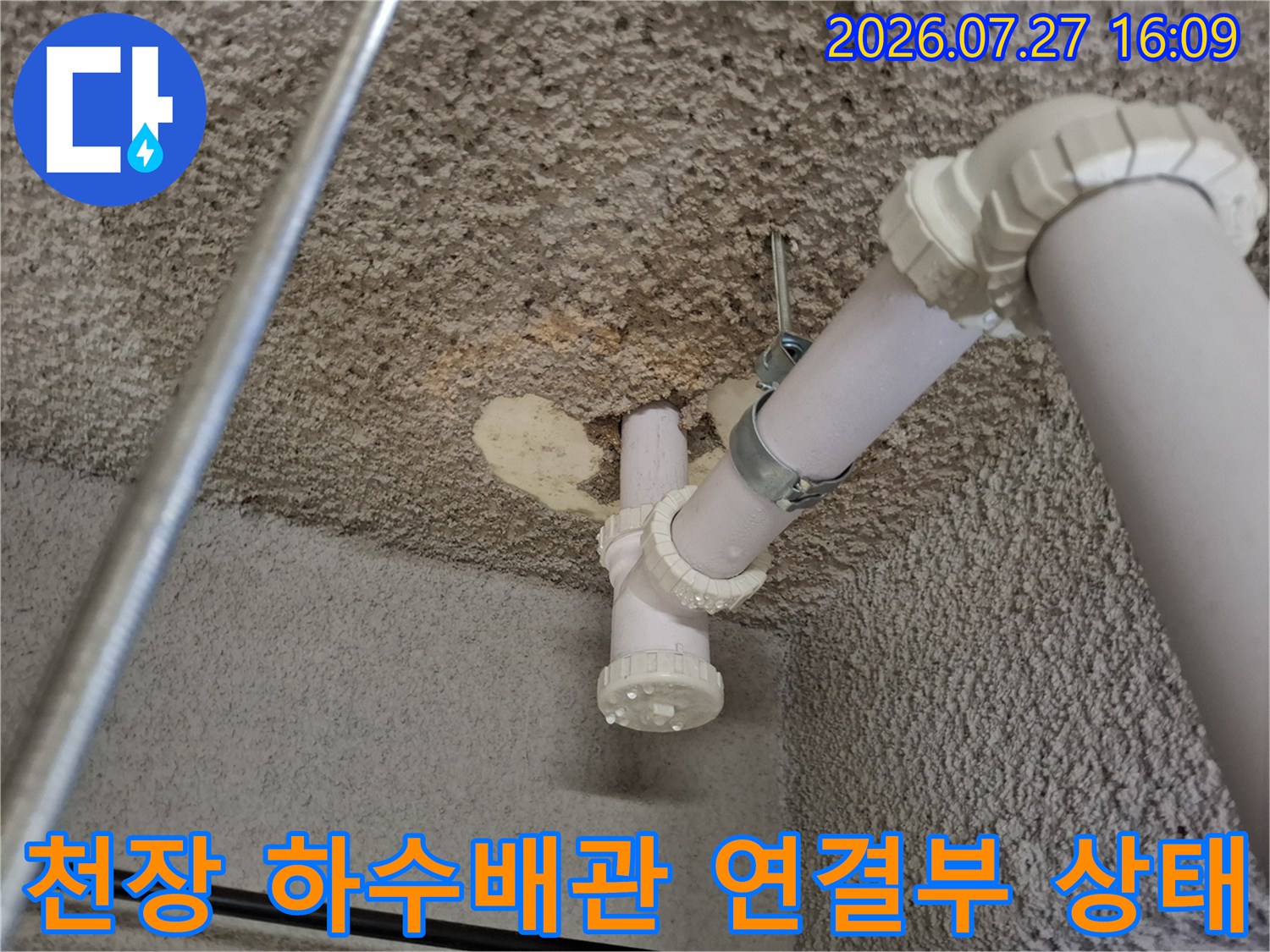 지하층 천장에 설치된 흰색 PVC 배관의 연결 부위와 주변 콘크리트 천장 모습