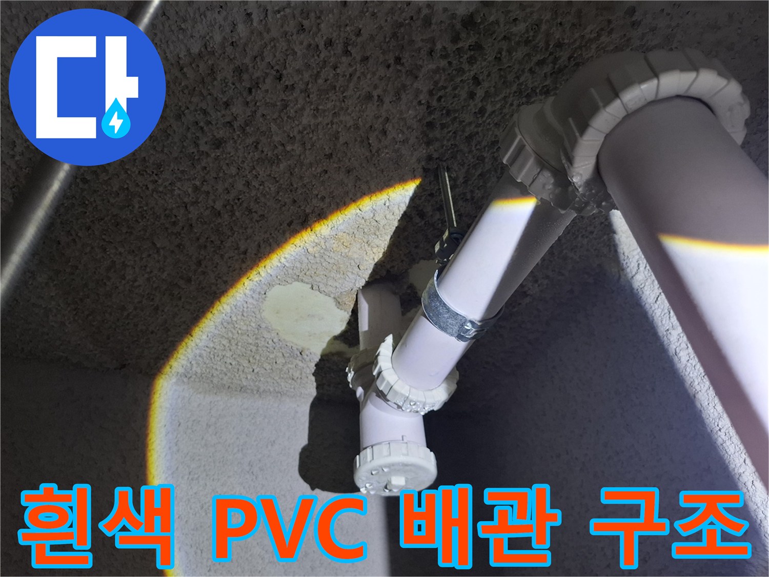 천장에 고정된 흰색 하수 배관과 연결 부속품