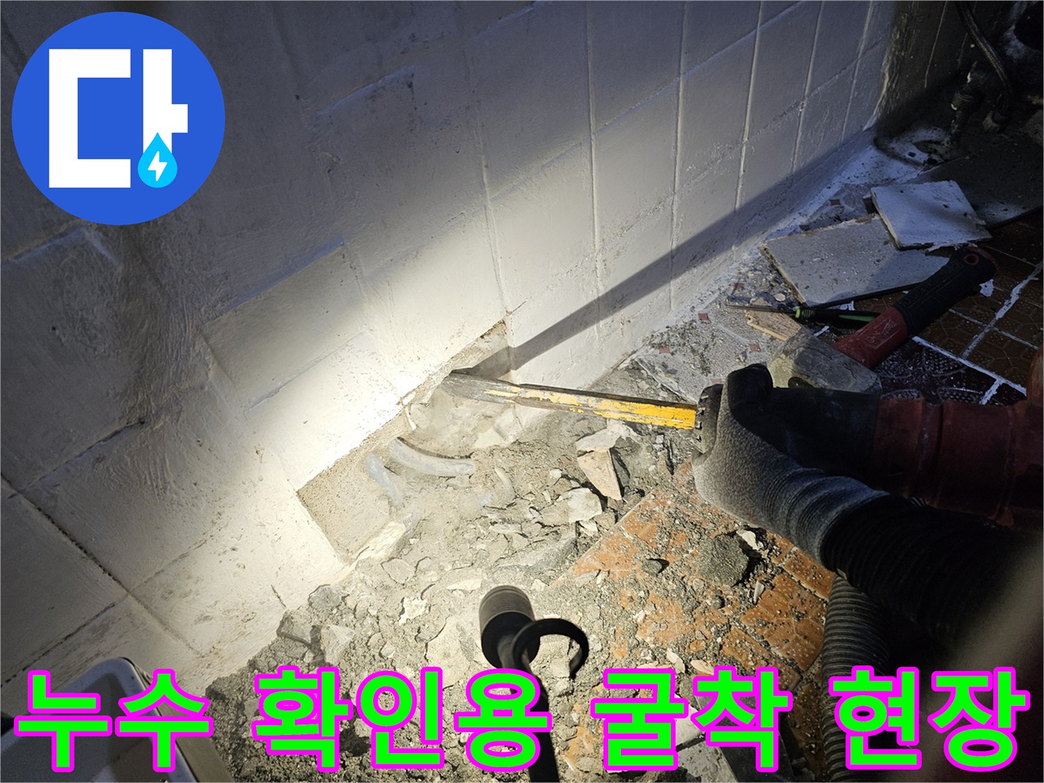 배관 상태를 보기 위해-파손된 타일과 드러난 벽면 부위