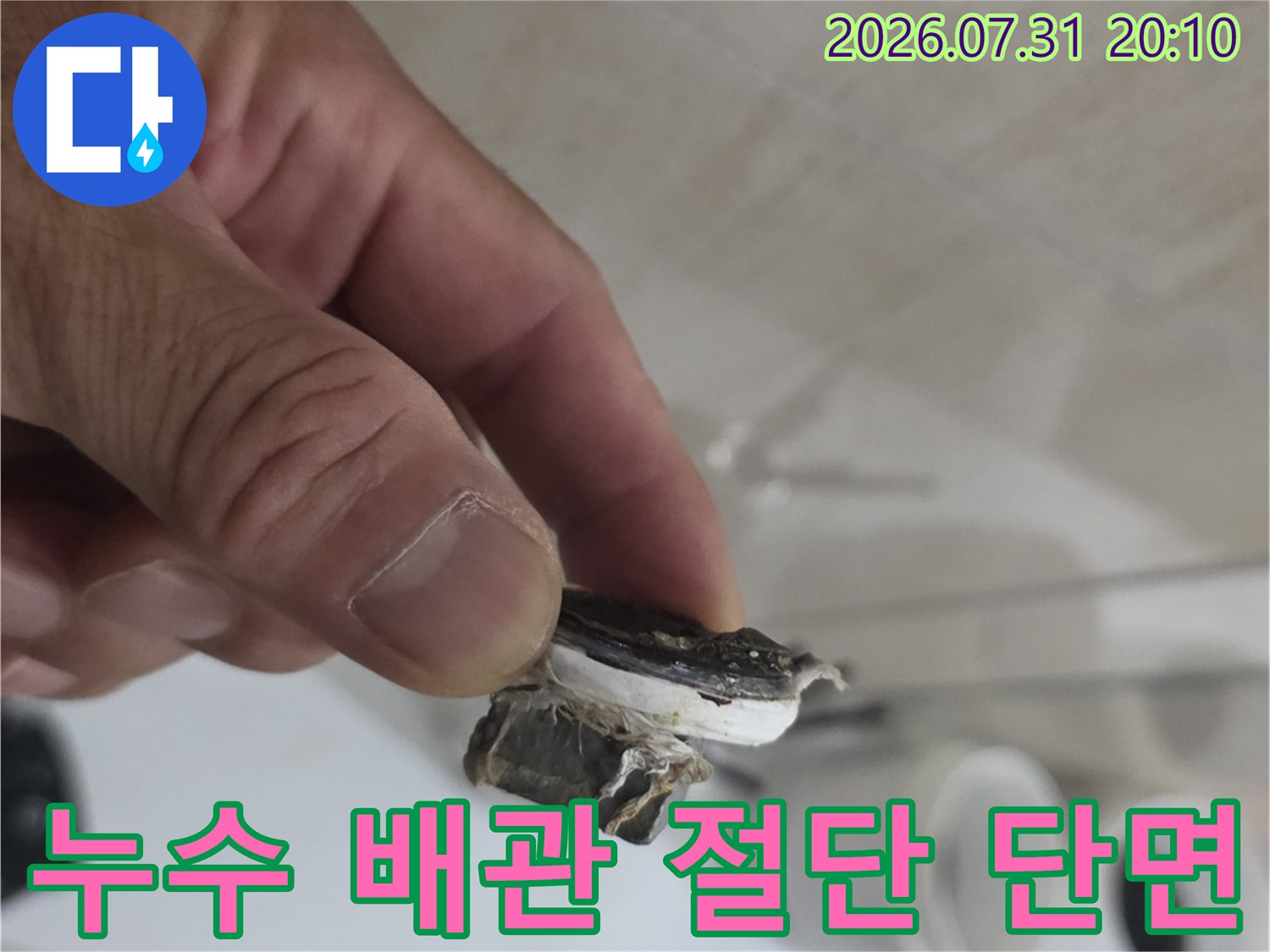 손으로 들고 보여주는 노후된 수도 배관의 파손 부위