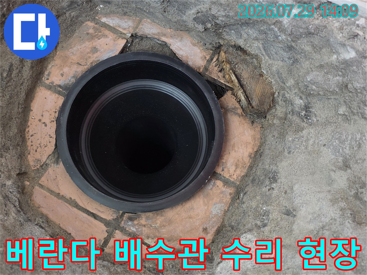 노출된 검은색 배수관과 주변 시멘트 마감 처리 모습