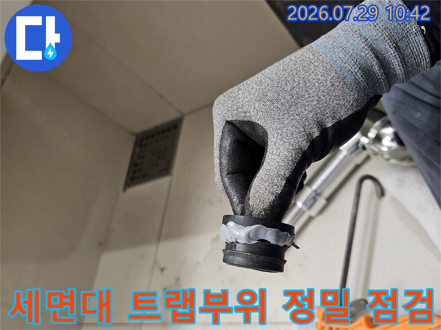 장갑을 낀 작업자가 세면대 배출용 플라스틱 부품 상태 확인
