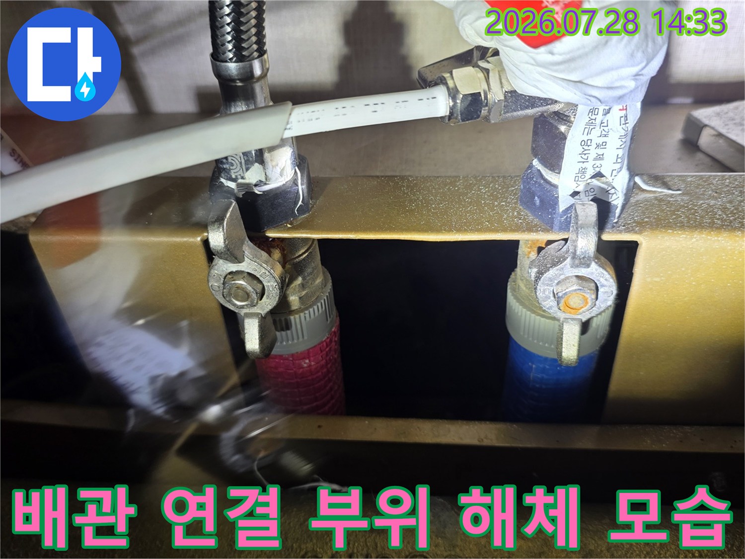 분배기에서 분리된 주름관과 그 아래로 떨어진 검은색 고무 패킹의 모습