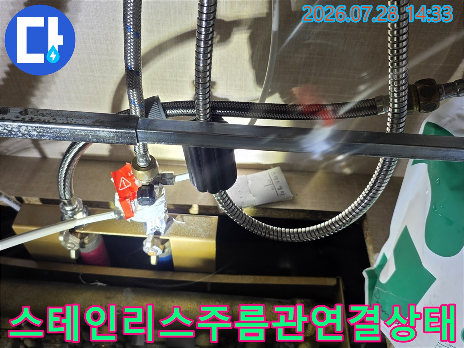 붉은색 밸브가 달린 분배기와 주름관 배관의 연결 상태 사진
