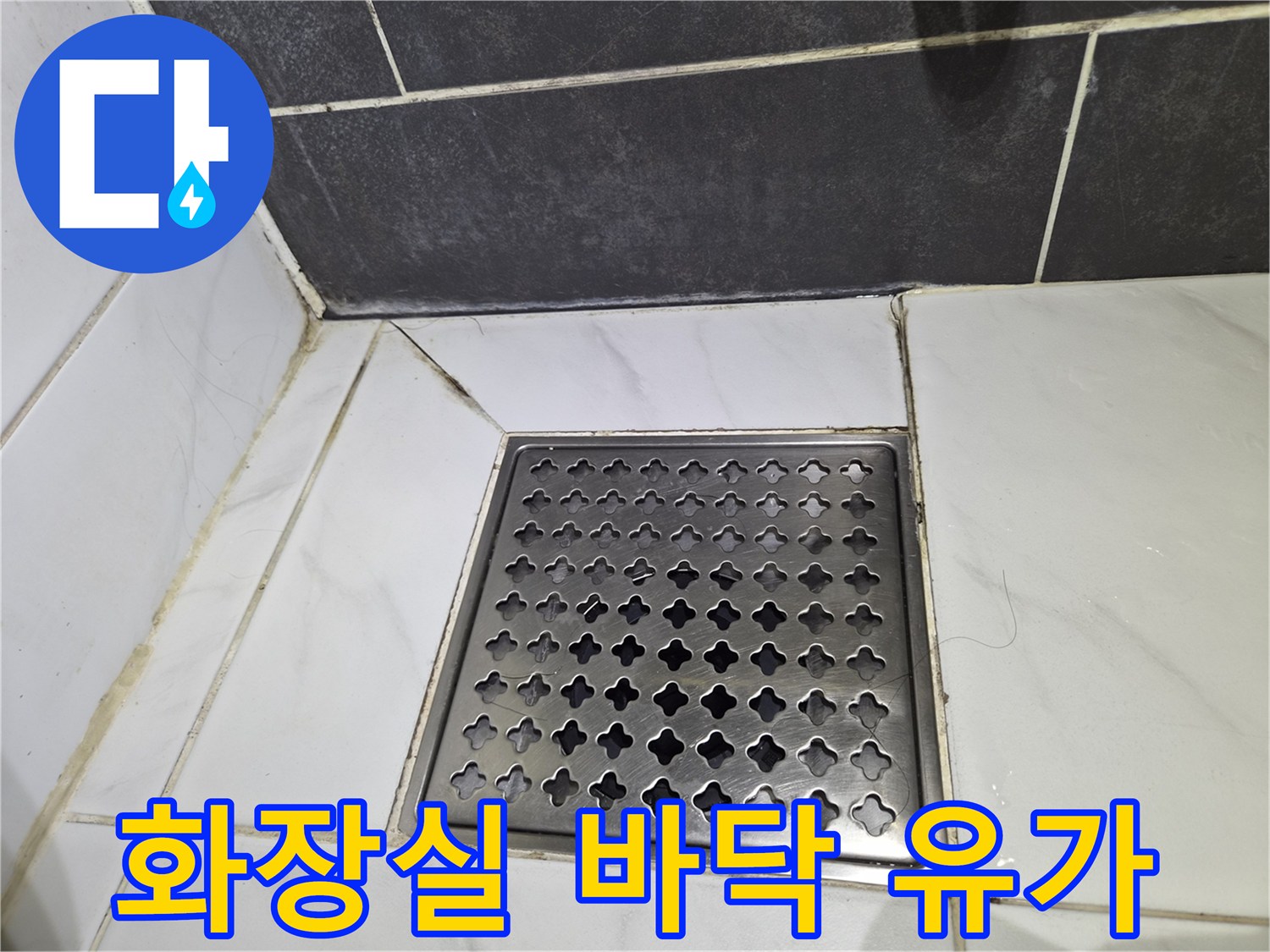 타일 사이에 설치된 금속 재질의 배수구 덮개