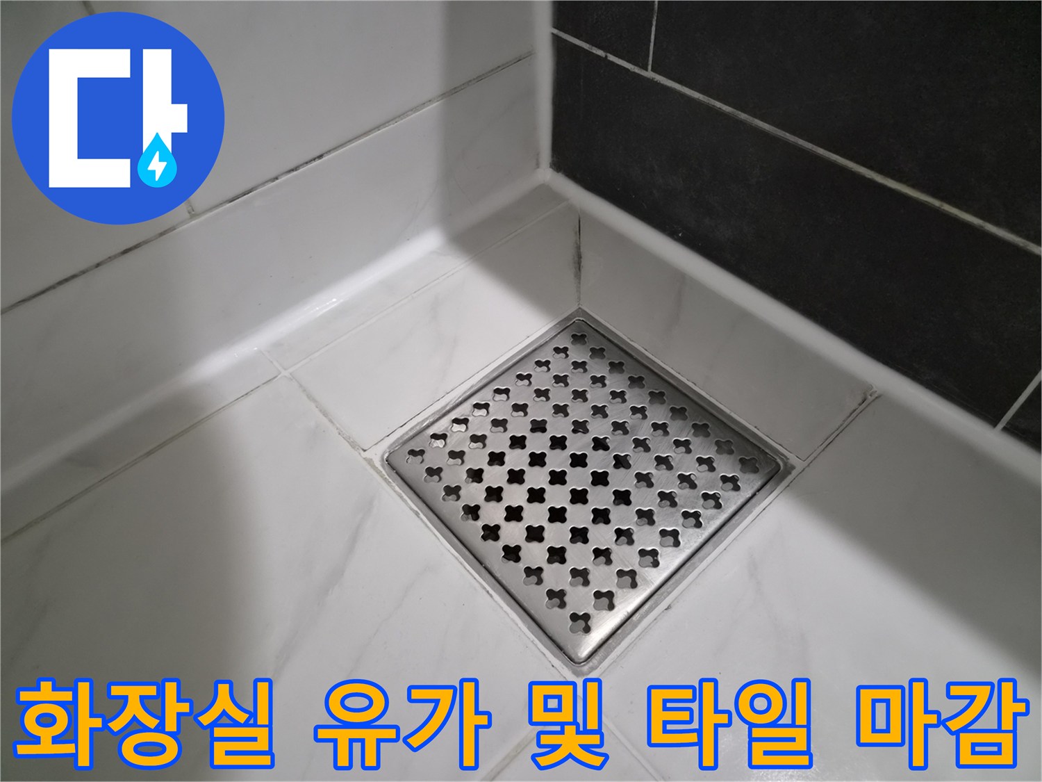 하얀색 타일과 금속제 배수구의 접합부 모습