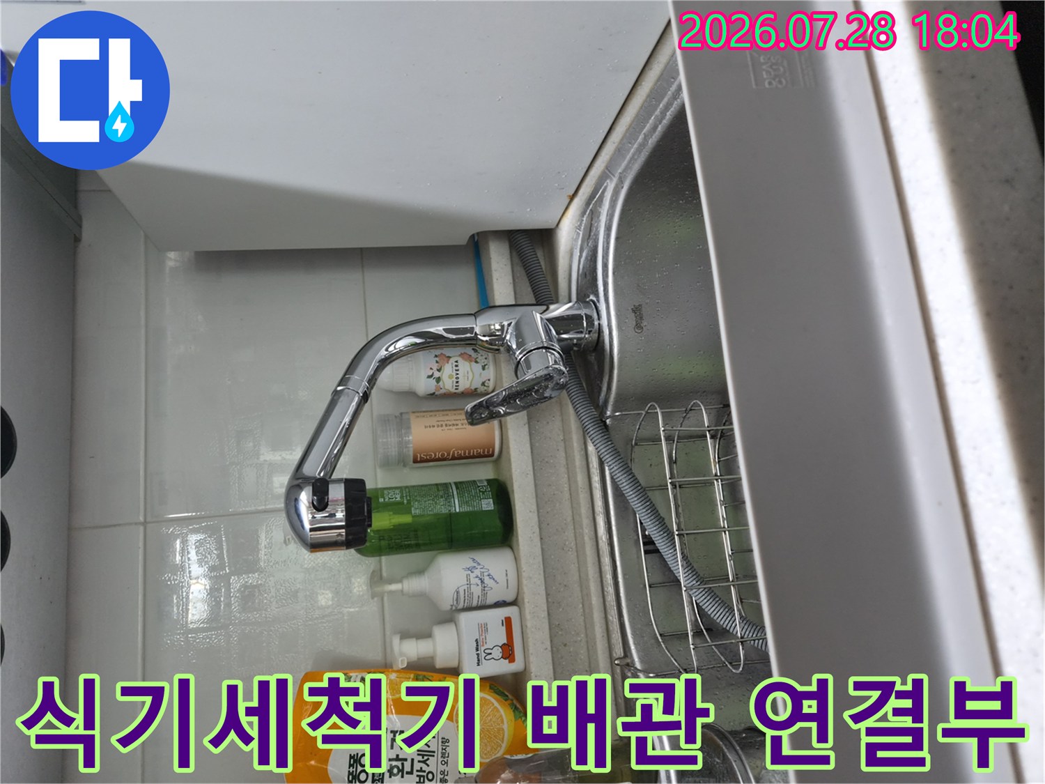 싱크대 하단 수전과 식기세척기 호스 연결 지점 상세 촬영