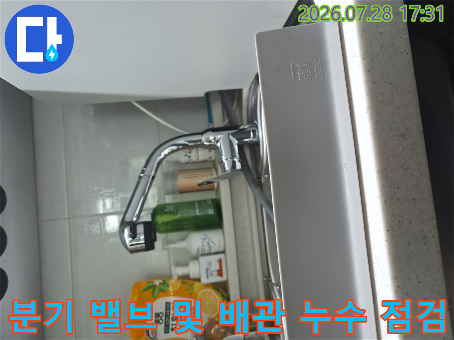 싱크대 하단부에 위치한 식기세척기용 분기 밸브와 연결 호스의 상태를 확인하는 장면
