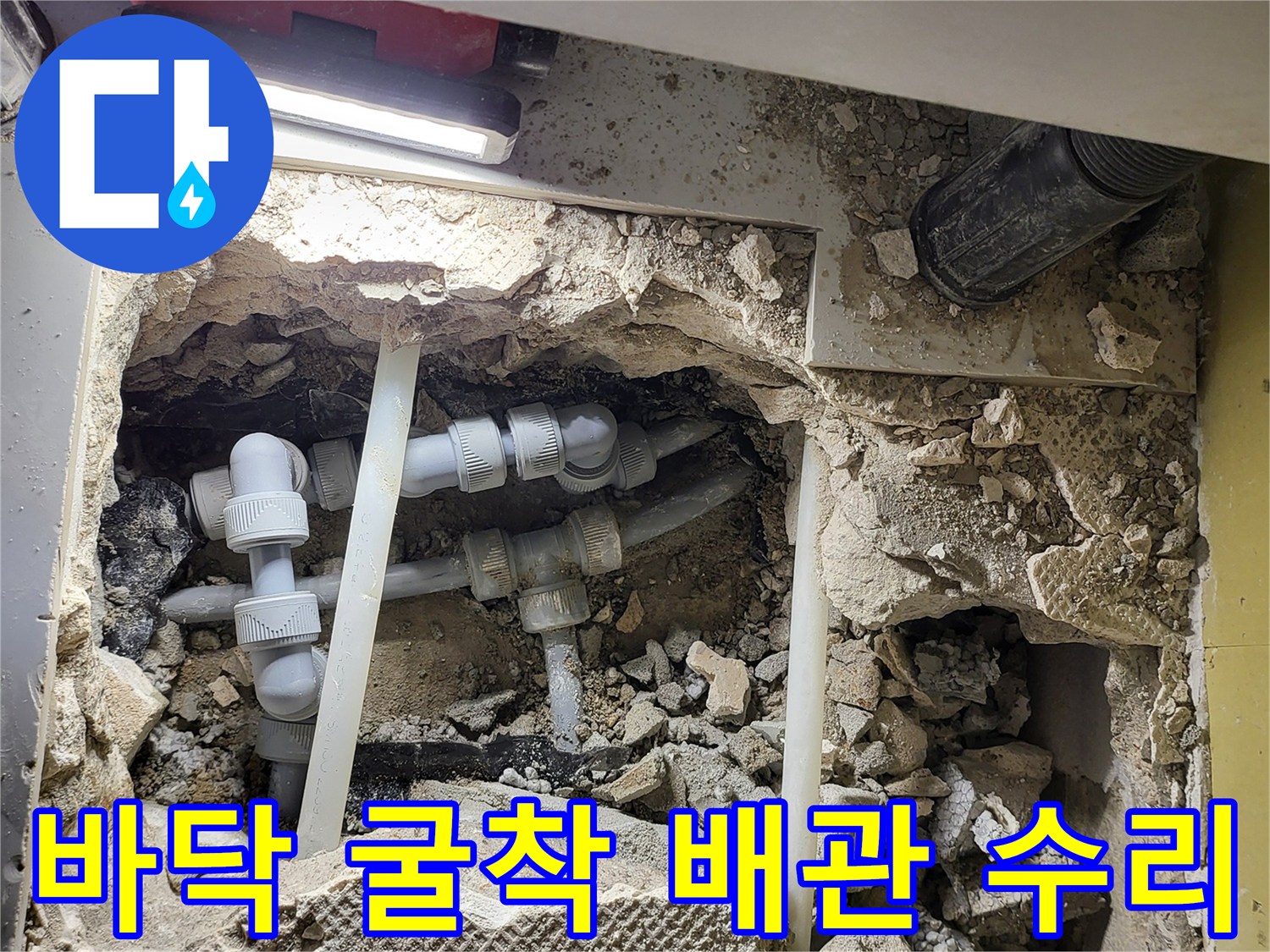 콘크리트 파쇄 부위-새로 연결된 흰색 배관과 결합 부속
