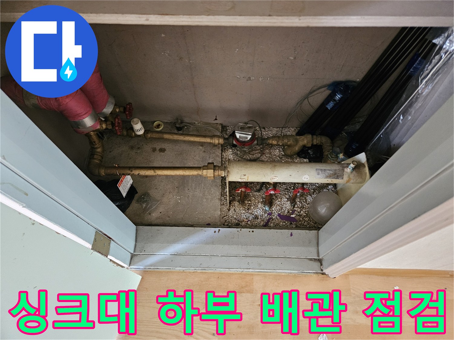 복잡하게 얽힌 싱크대 하부의 금속 배관과 밸브 연결 부위