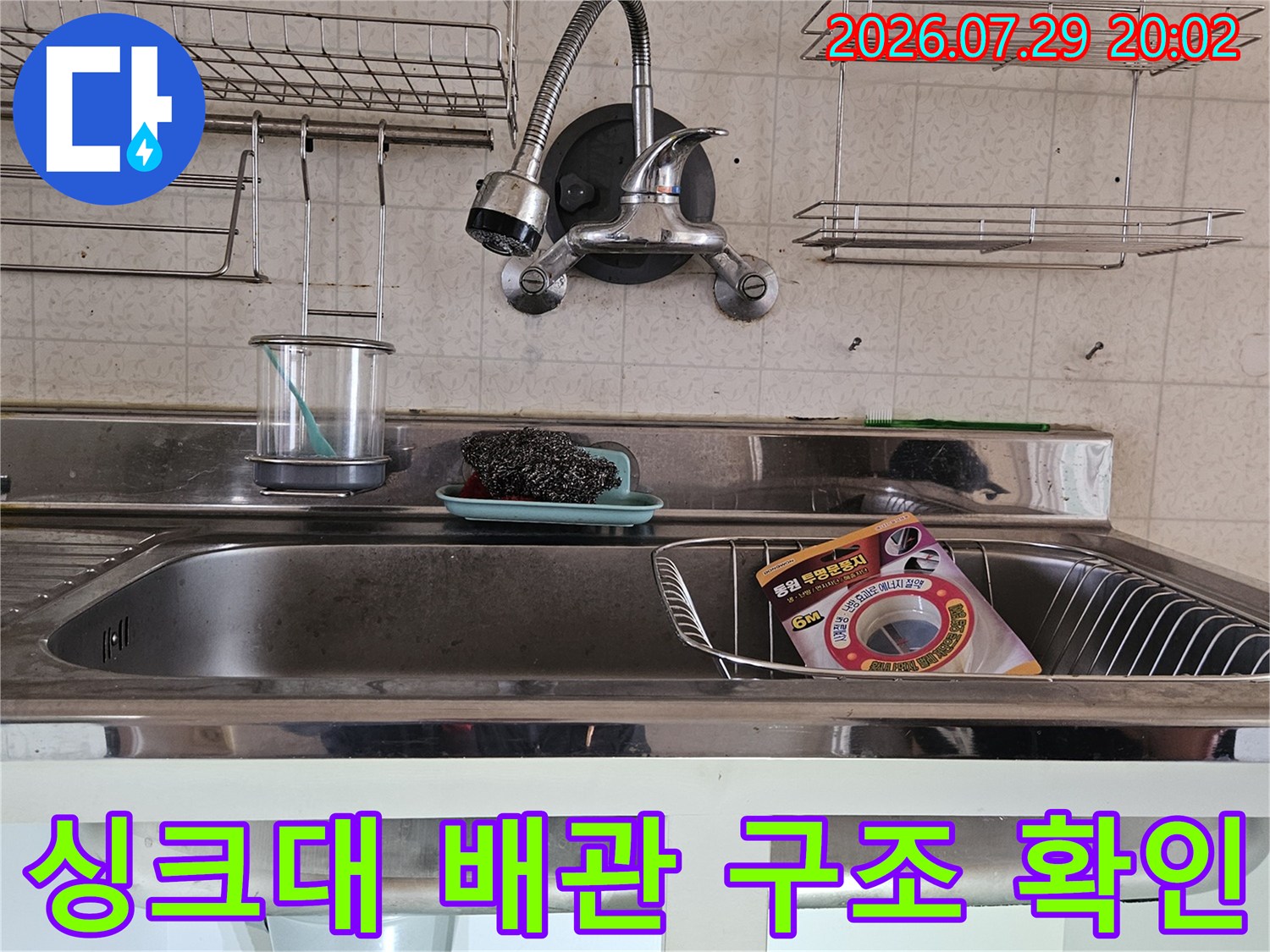 싱크대와 세면대가 인접한 공간의 복잡한 배관을 정밀 점검하는 모습