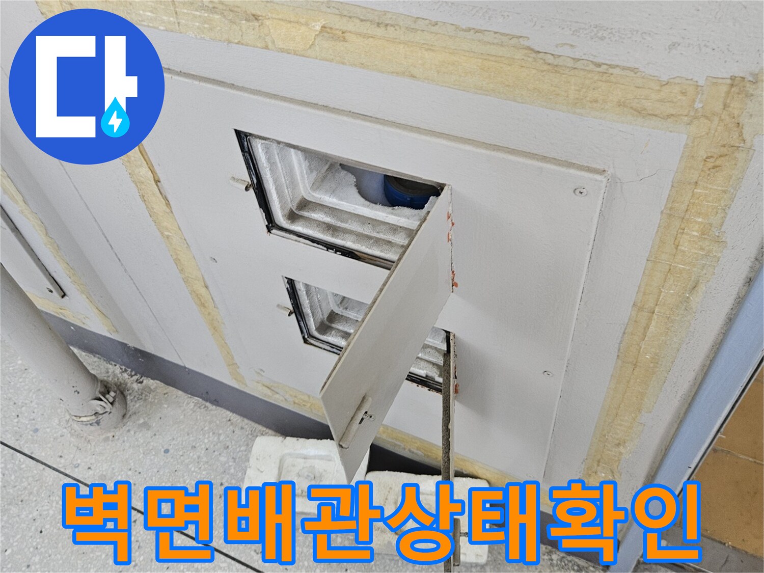 점검구 안쪽의 배관 연결 부위와 벽면 마감재 근접 촬영