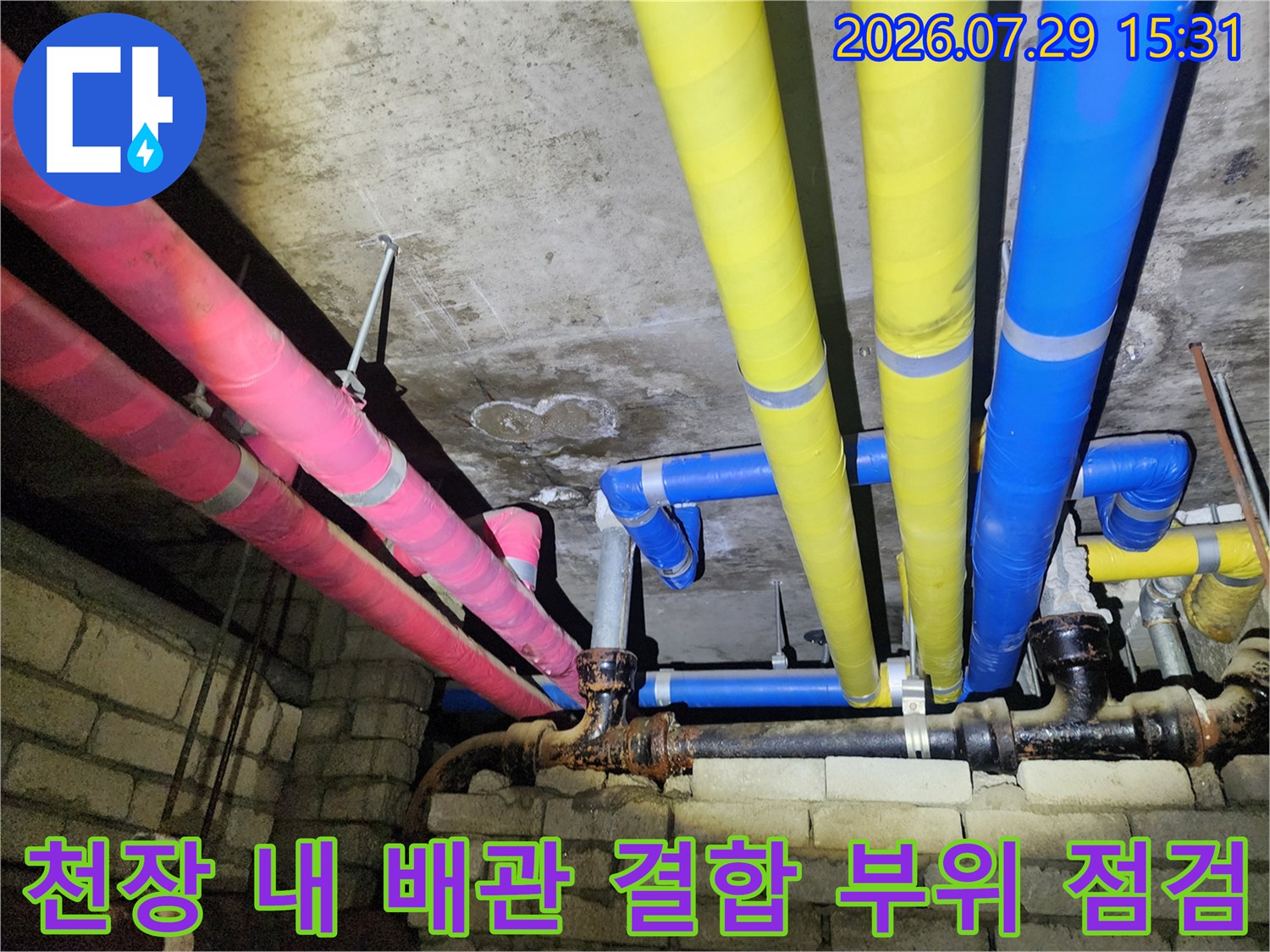 천장 속 노란색과 분홍색 그리고 파란색으로 구분된 보온재를 씌운 배관들의 교차 지점