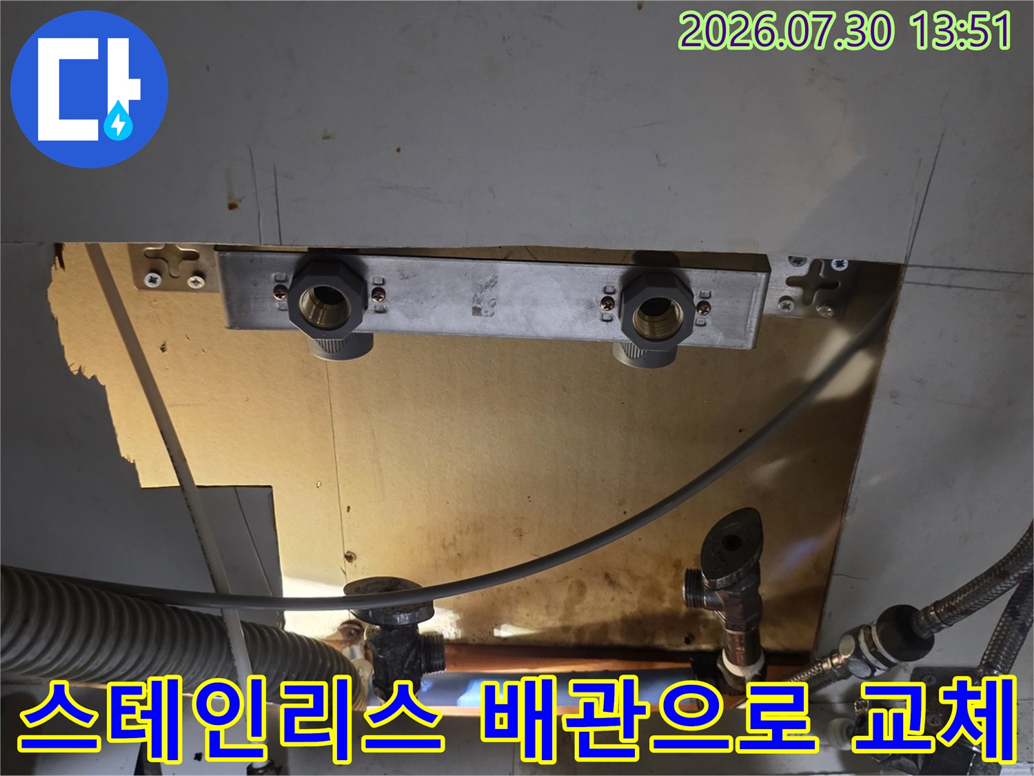 싱크대 하단 공간에 스테인리스 주름관과 고정 브래킷을 설치하는 장면