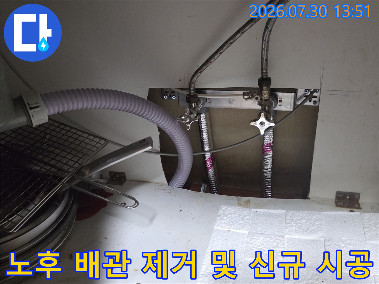 싱크대 하단에 설치된 스테인리스 주름관과 고정 브래킷의 상세 모습