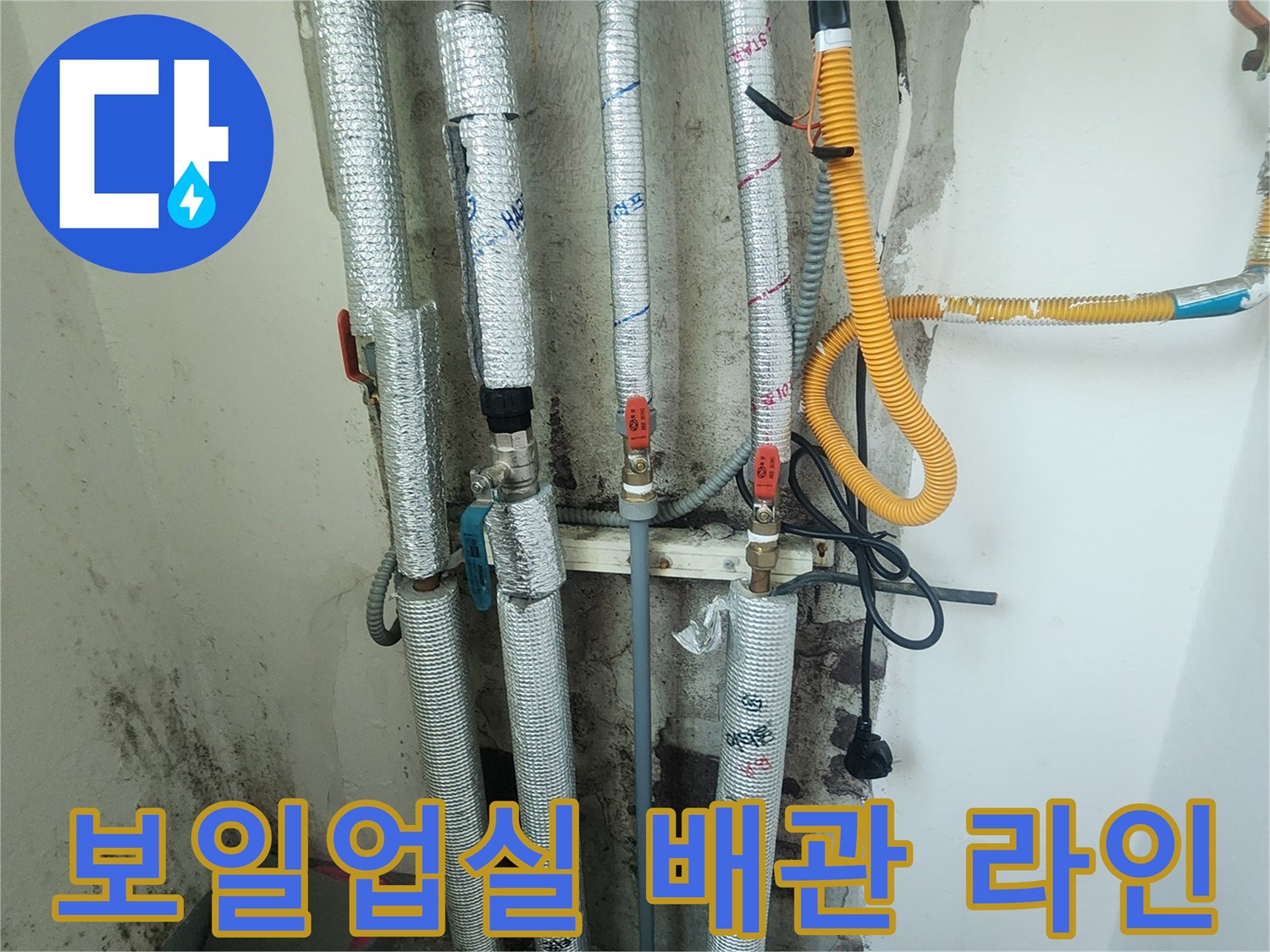 노란색 호스와 흰색 단열재가 씌워진 보일러실 배관 사진