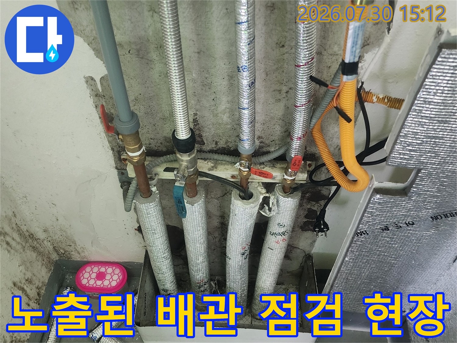 은박 마감재로 감싸진 보일러 배관과 밸브가 설치된 세탁실 내부 모습