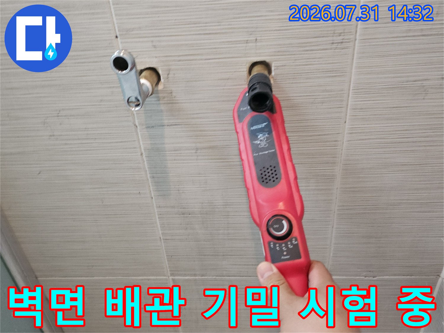 샤워 수전 부위의 배관에 압력계를 연결하여 누수 여부를 판별하는 장면