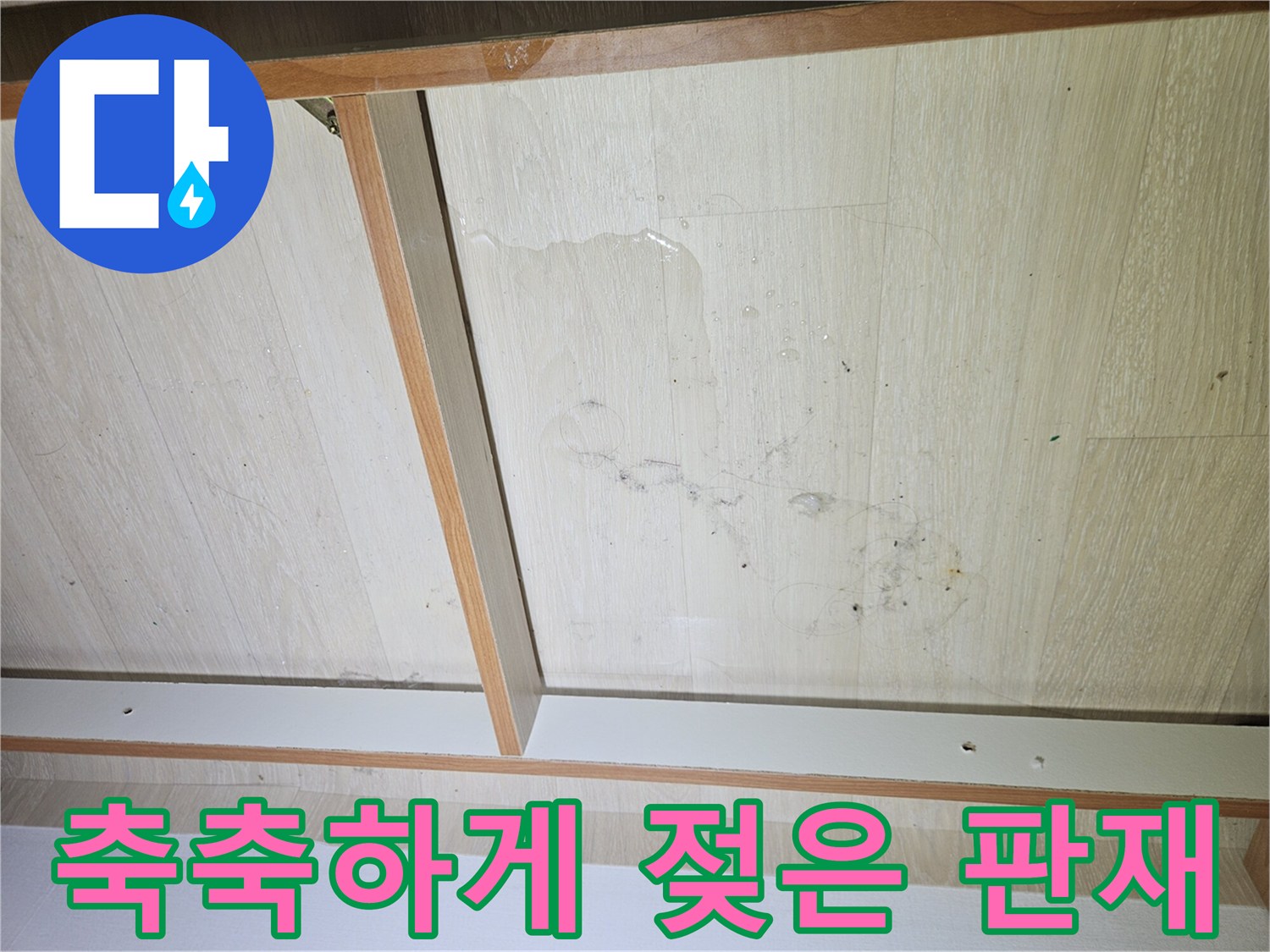 물기가 스며들어 얼룩진 장롱 하부 목재 표면