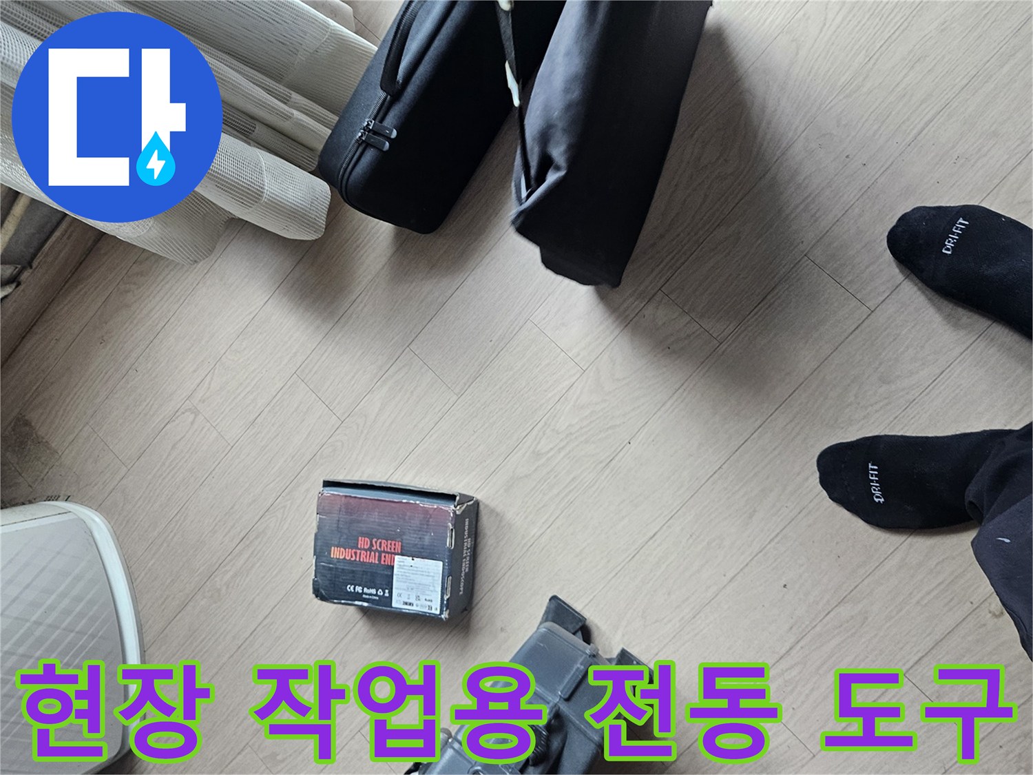 바닥에 준비된 노란색 드릴과 배관 점검용 공구 세트