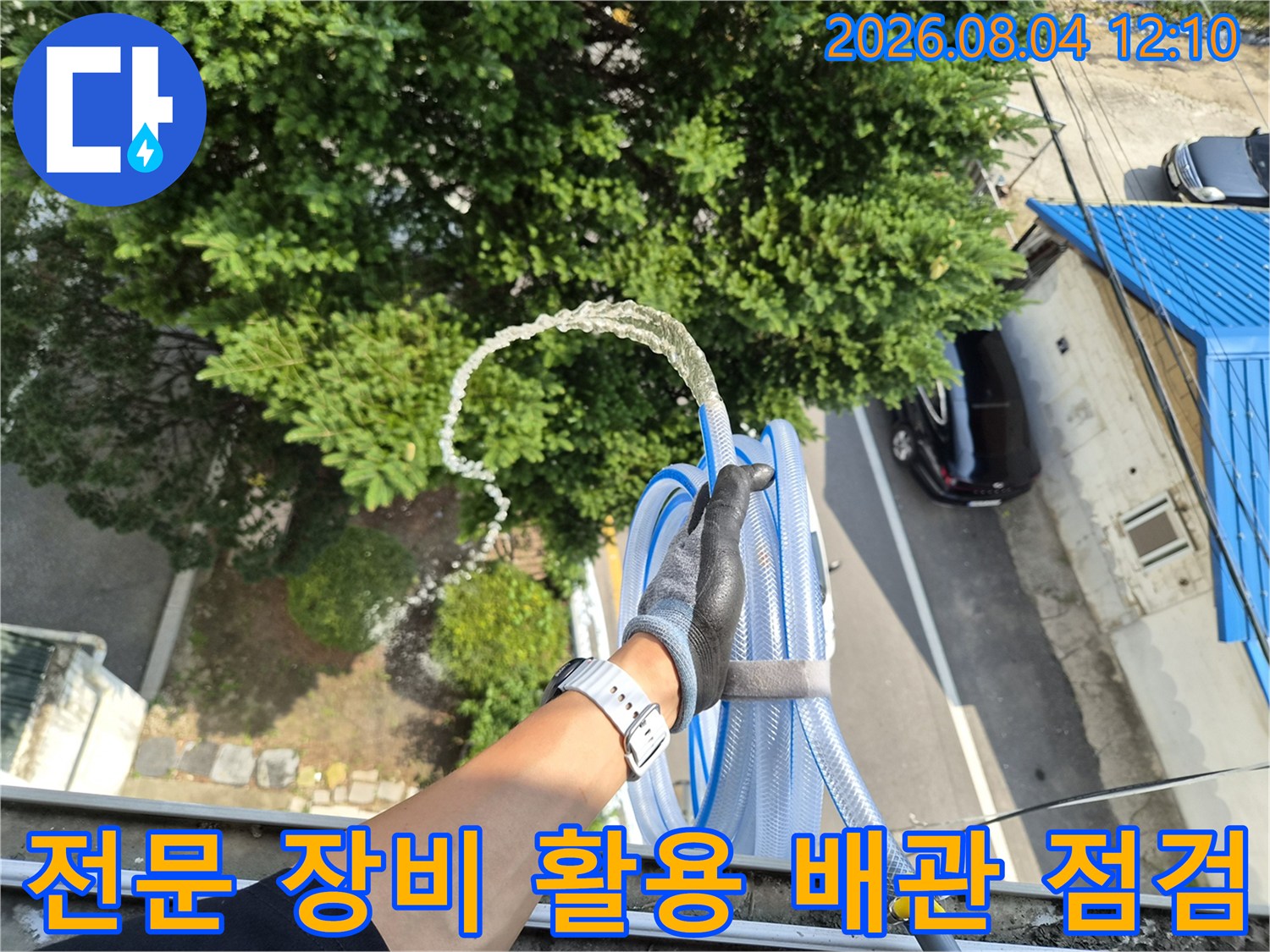 고무장갑을 낀 손이 배관과 호스를 잡고 상태를 세밀하게 살피는 장면