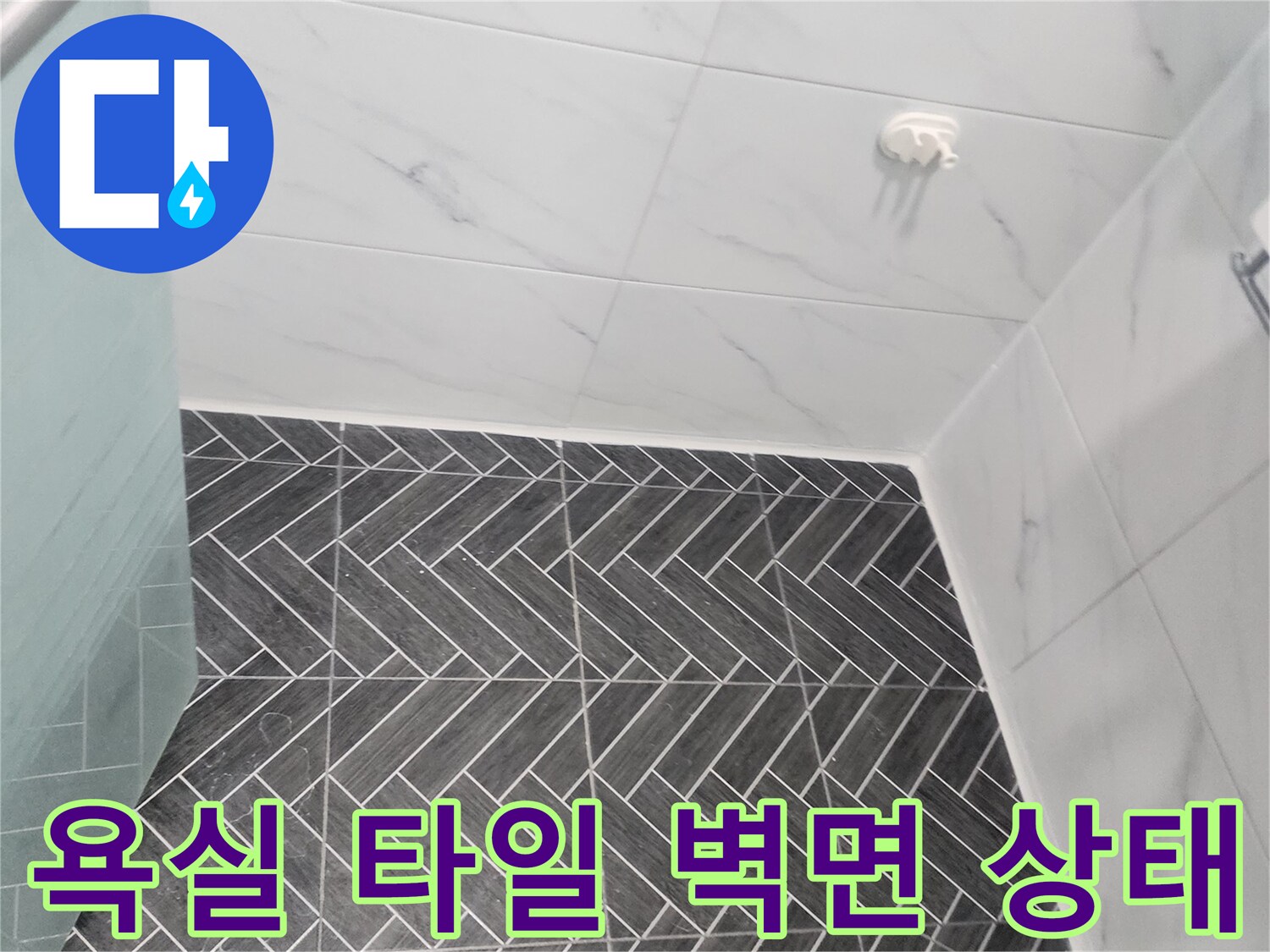 용인 수지구 화장실-헤링보로 패턴의 어두운 타일과 흰색 대리석 타일이 만나는 지점