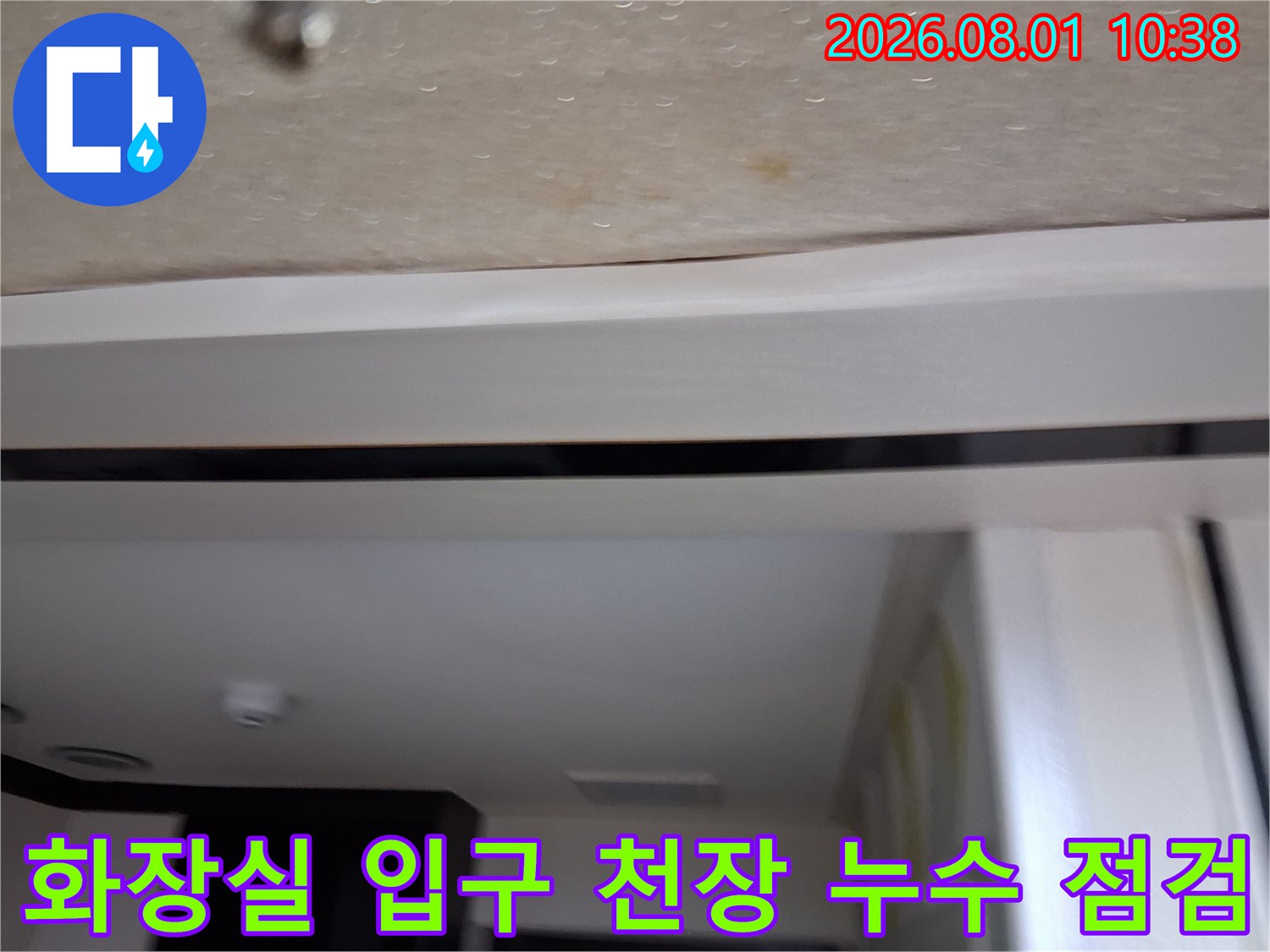 화장실 입구 쪽 천장 몰딩과 벽면 자재에 발생한 누수 흔적을 촬영한 사진