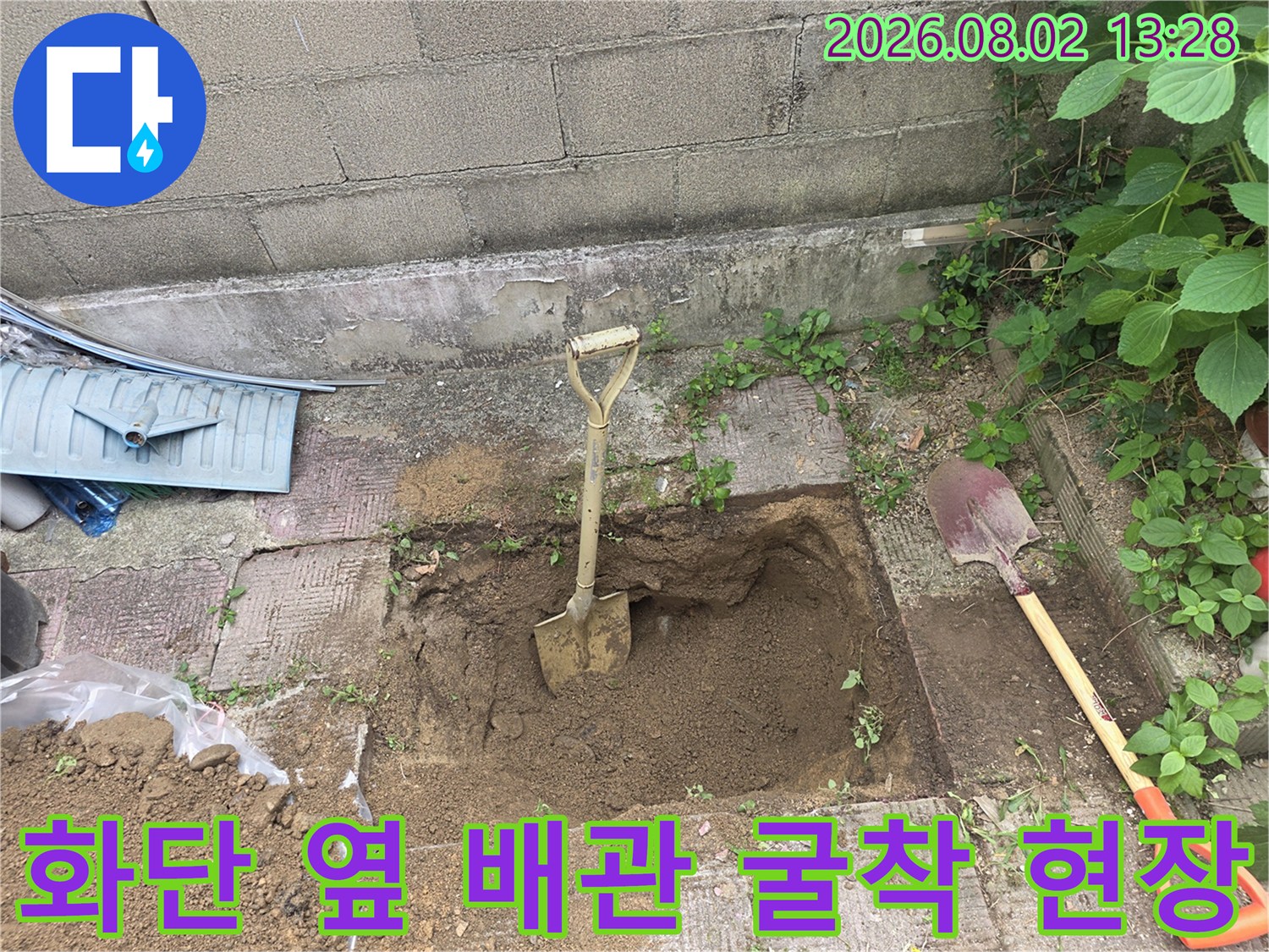 노란색 손잡이의 삽과 파헤쳐진 흙더미로 구성된 누수 공사지