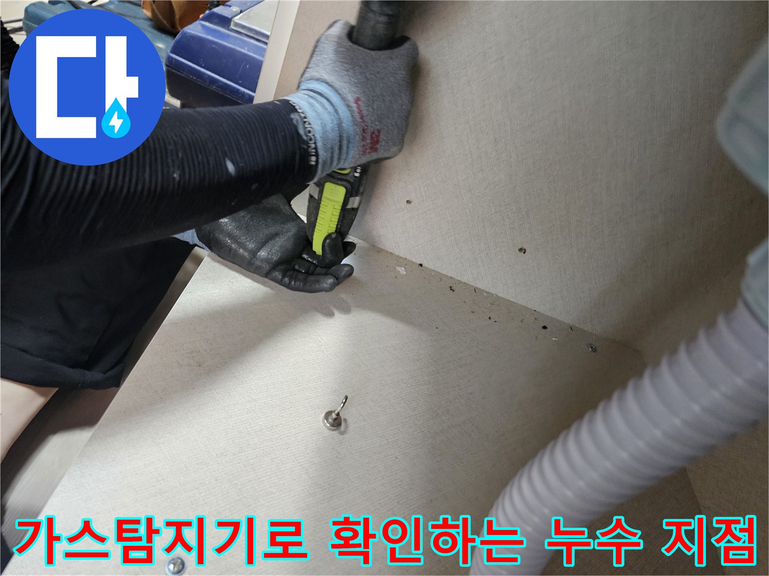 가스 탐지기를 사용하여 가구 하단 배관의 누수 위치를 추측하는 장면