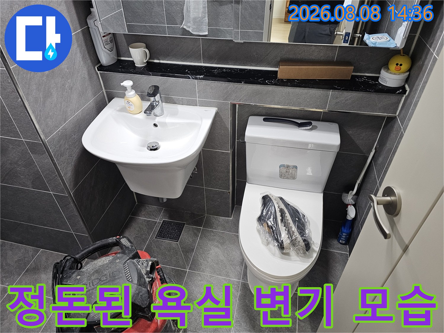 누수 공사 완료 후 깨끗하게 정리된 화장실 변기와 세면대 전경입니다.