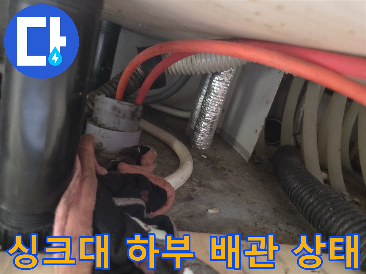싱크대 아래쪽 붉은 호스와 흰색 배관의 연결 모습