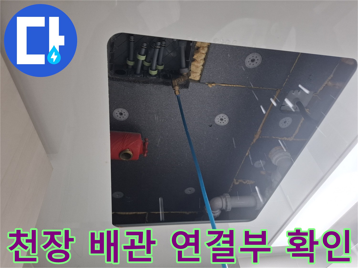 점검구 내부의 직수 배관과 붉은색 유틸리티 부품