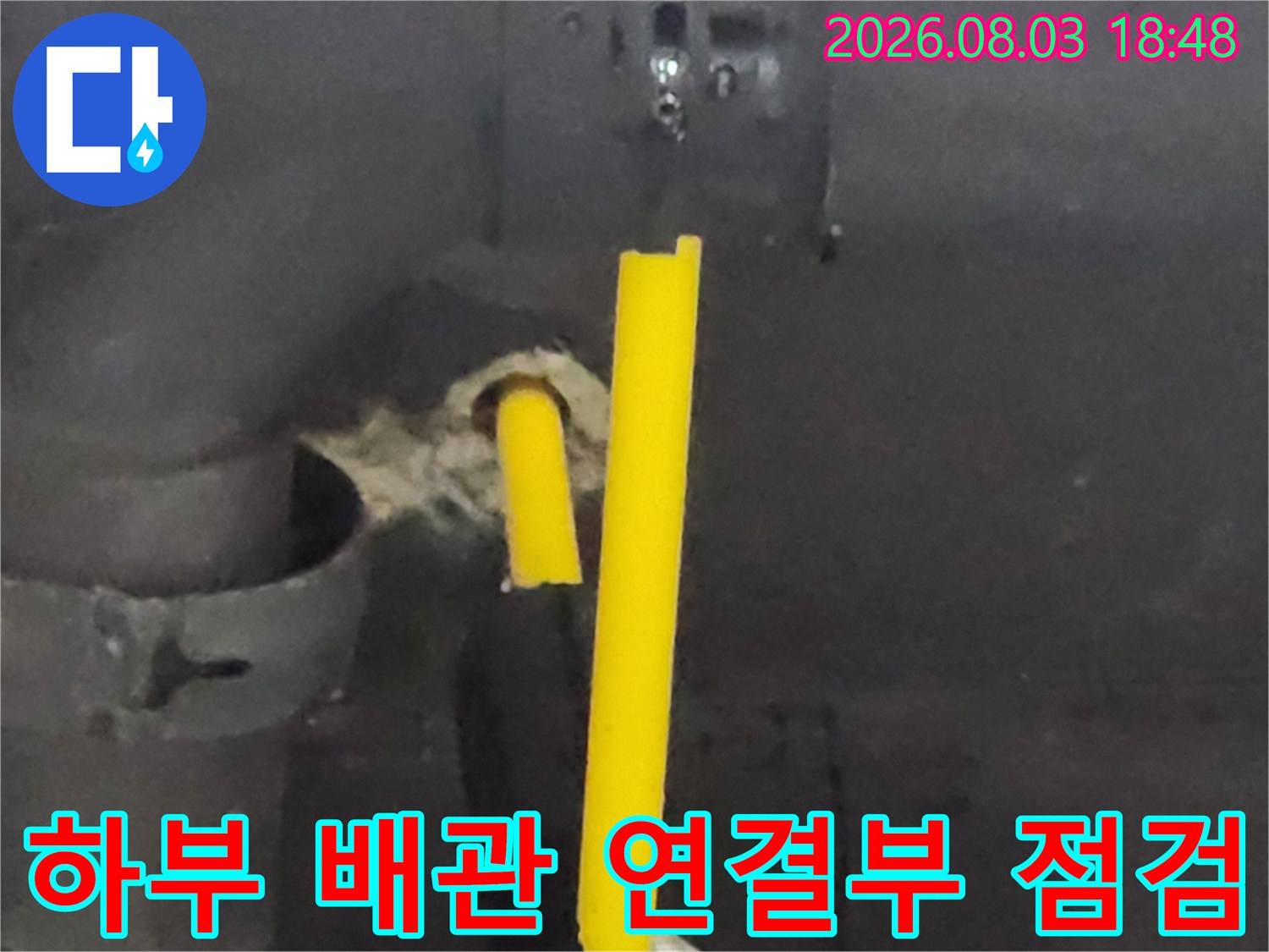 노란색 도색 배관과 유연한 호스 연결 부위를 근접 촬영한 사진입니다.