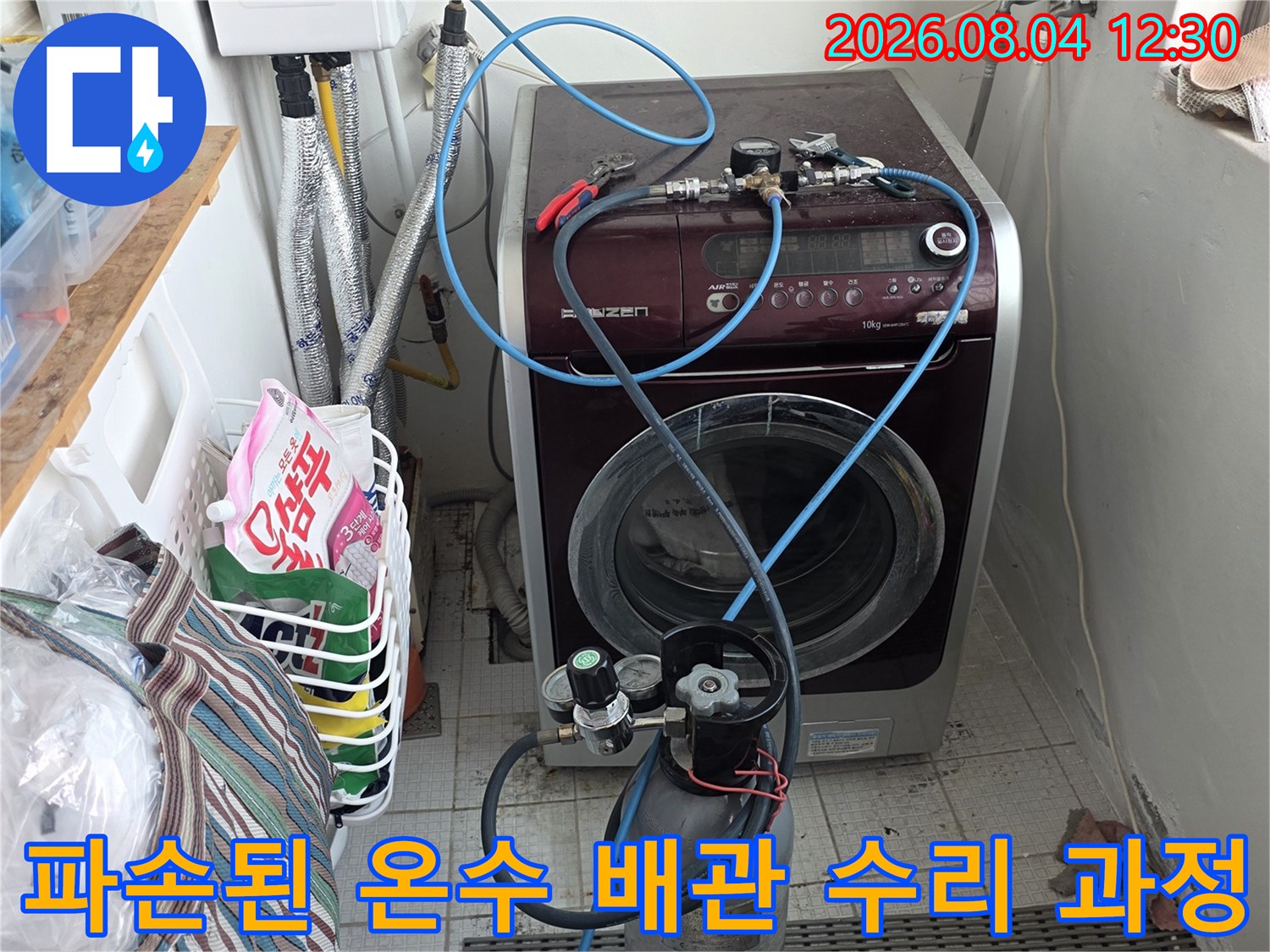 수리 중인 노출 배관에 장비와 호스가 연결된 모습