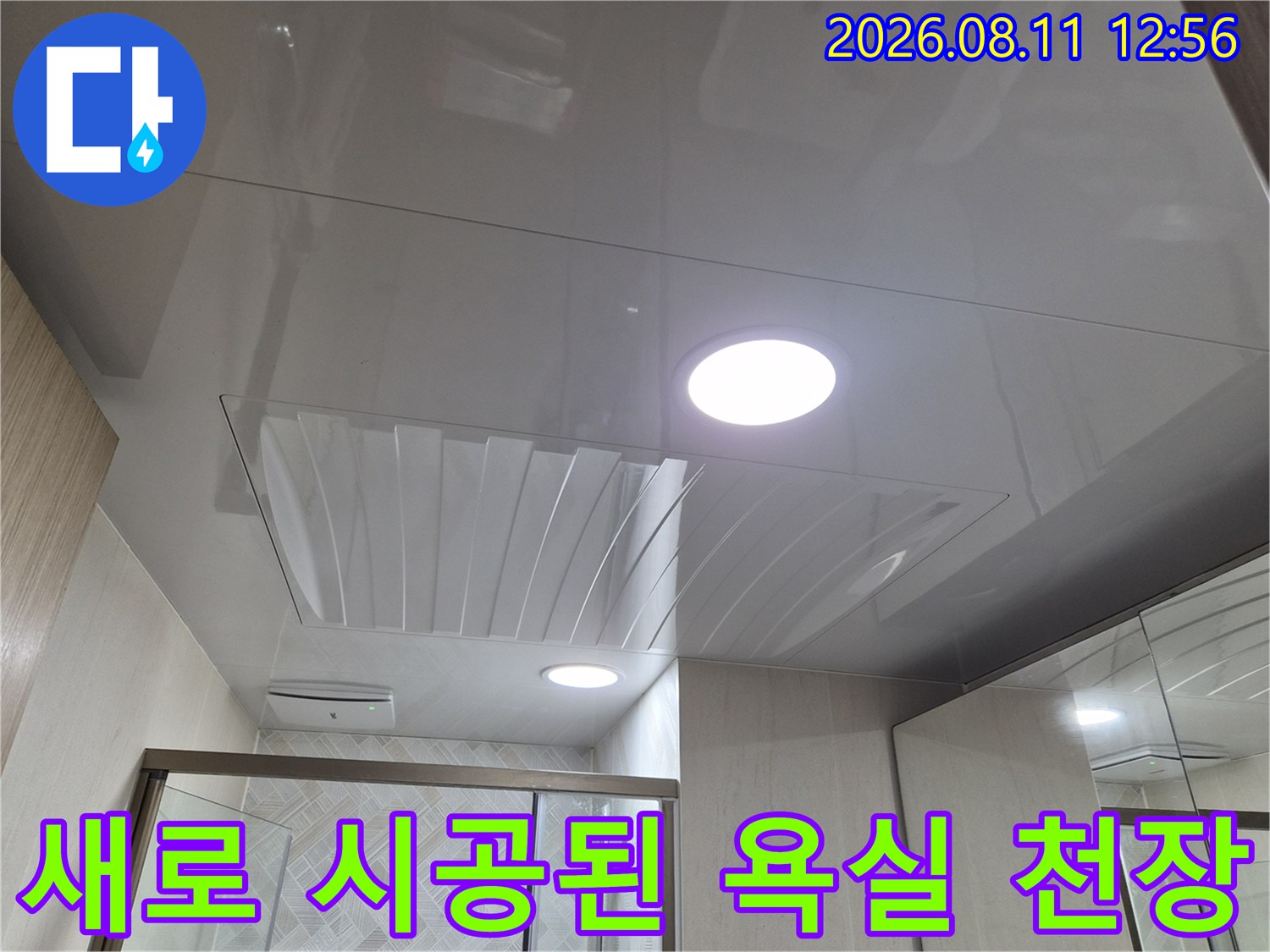 매립등 조명이 켜진 깨끗하고 광택 있는 욕실 천장 마감재입니다.