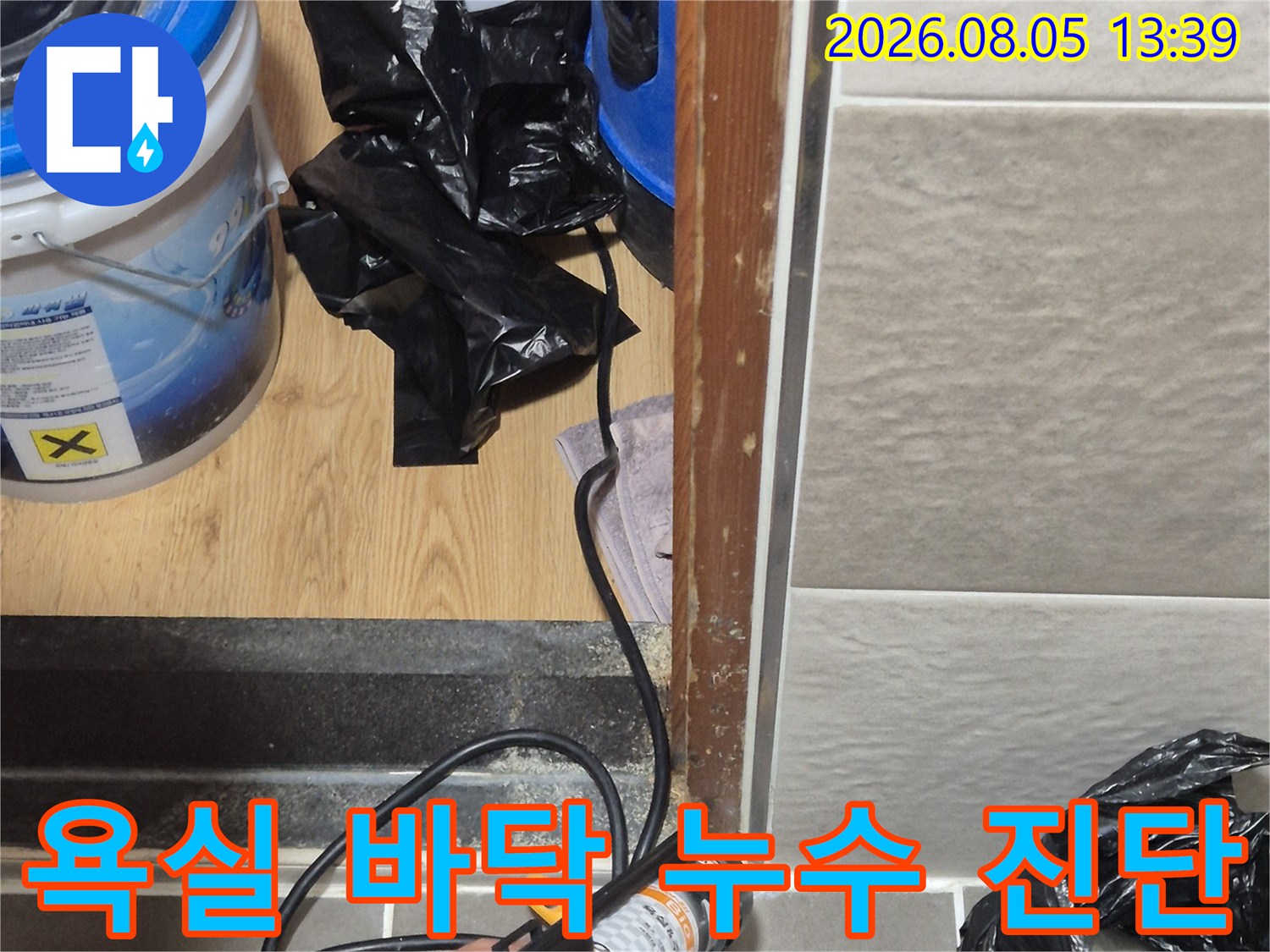 화장실 배수구 부위의 누수를 확인하기 위해 정밀 장비와 도구를 사용하는 모습