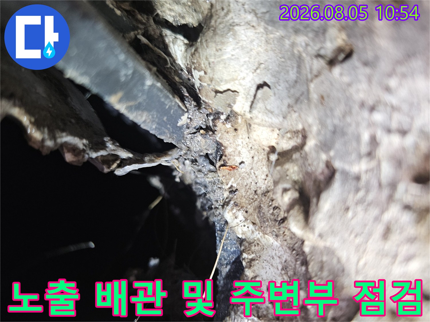 세탁기용 외부 노출 배관과 바닥면의 접촉 부위를 세밀하게 관찰하는 모습