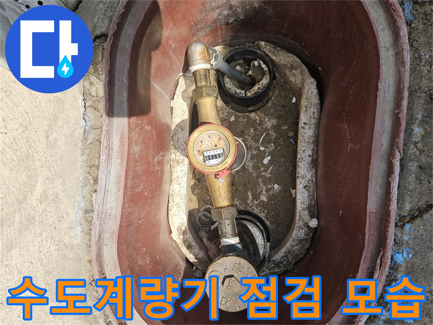 수도계량기와 연결 배관이 노출된 점검구 내부 사진입니다.