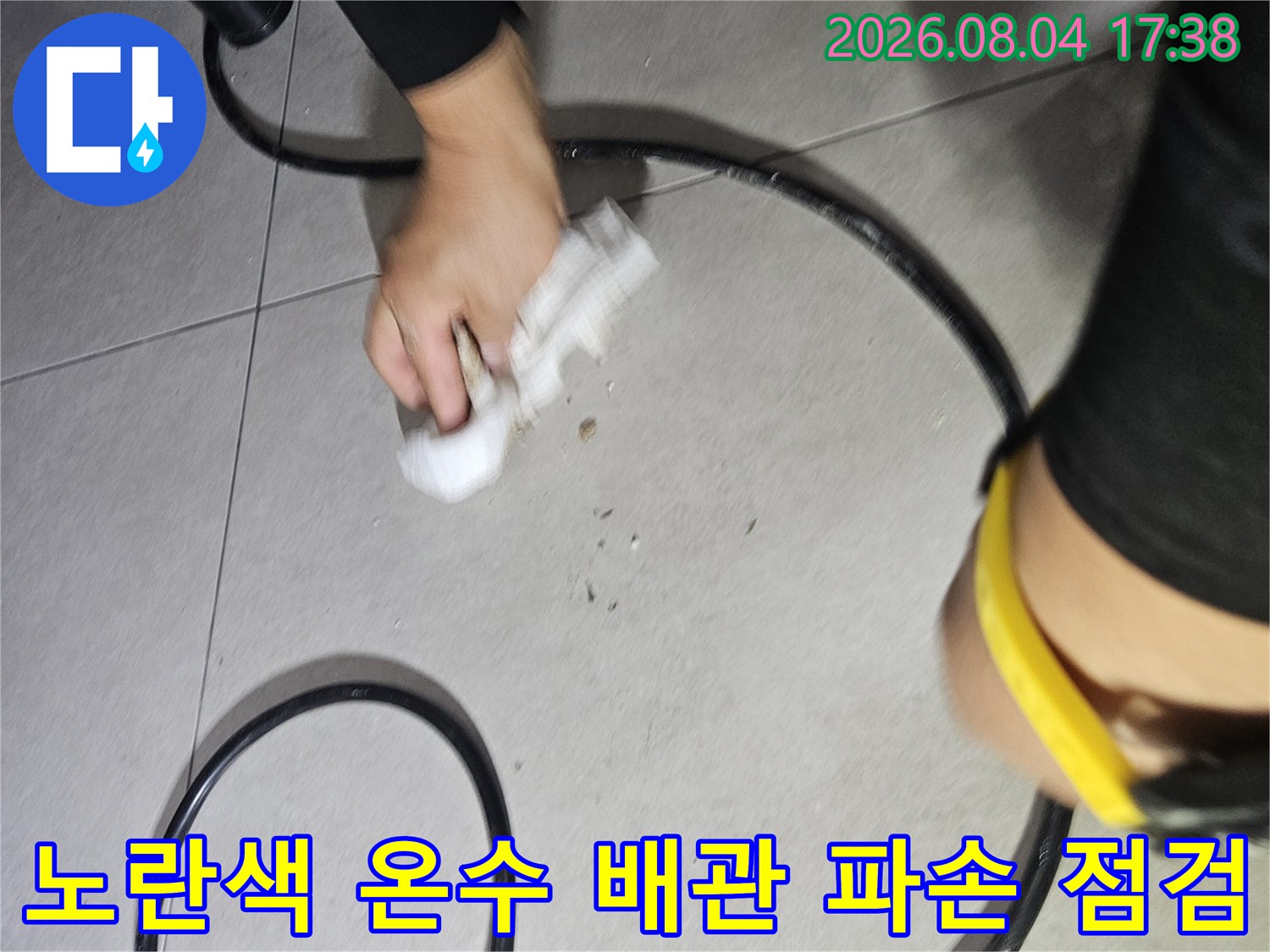 싱크대 하단 부위의 노란색 보온재가 씌워진 온수 배관을 면밀히 검사하는 장면