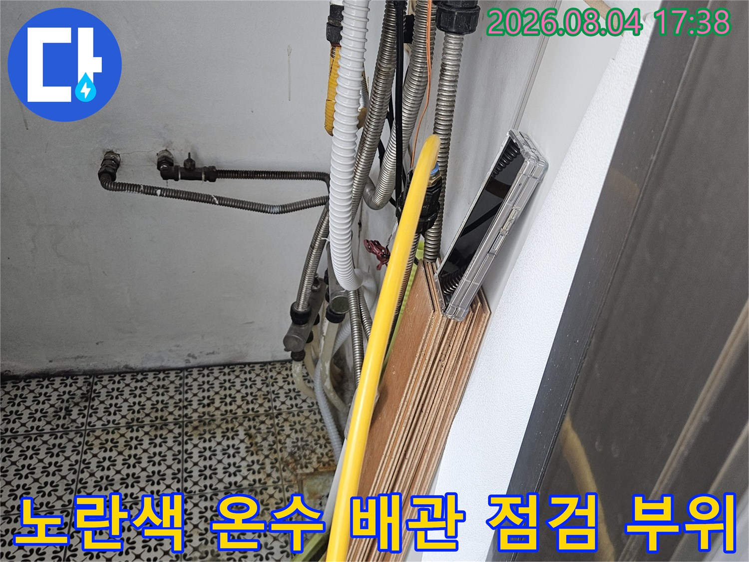 싱크대 하단부에 위치한 노란색 보온재 처리된 온수 공급 라인