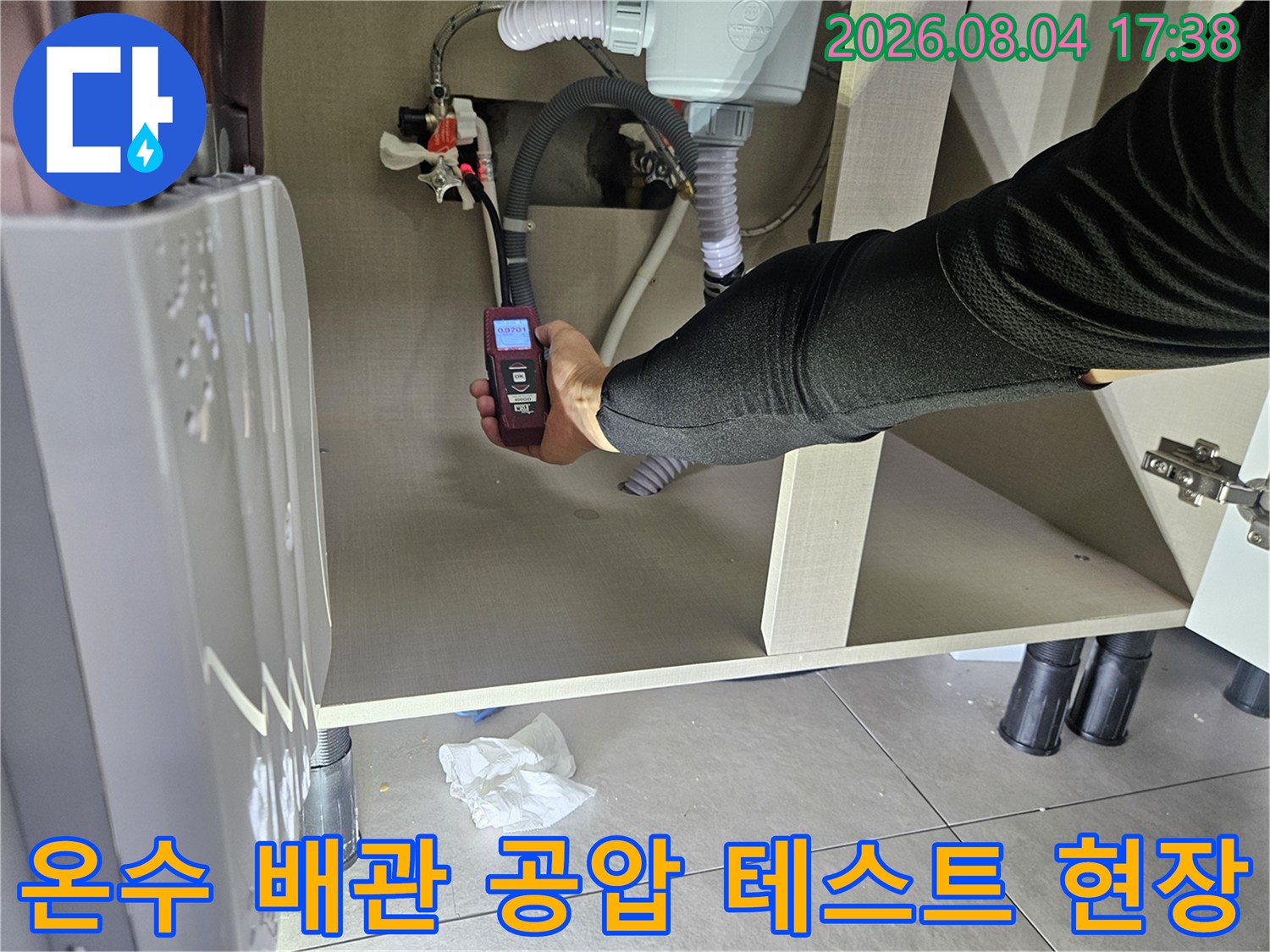 전문 장비로 온수 배관의 압력을 측정하여 누수 여부를 판별하는 장면