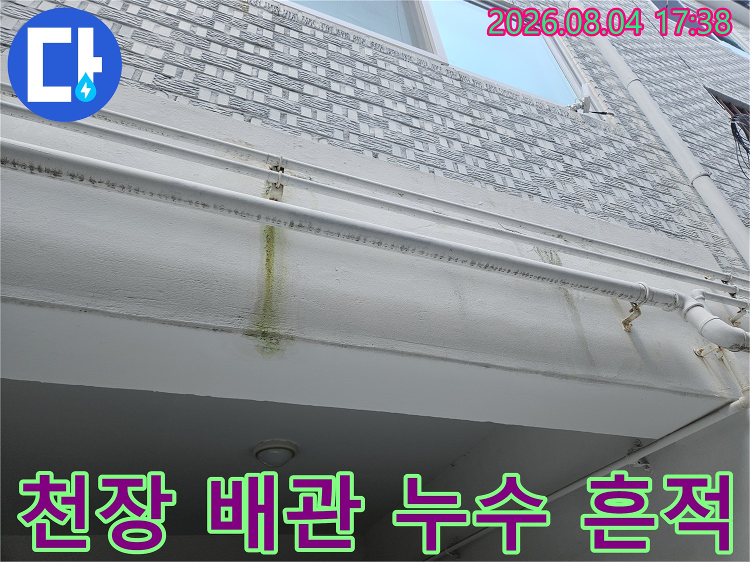 천장 콘크리트 부분에 발생한 갈색 물때와 노출된 배관의 모습
